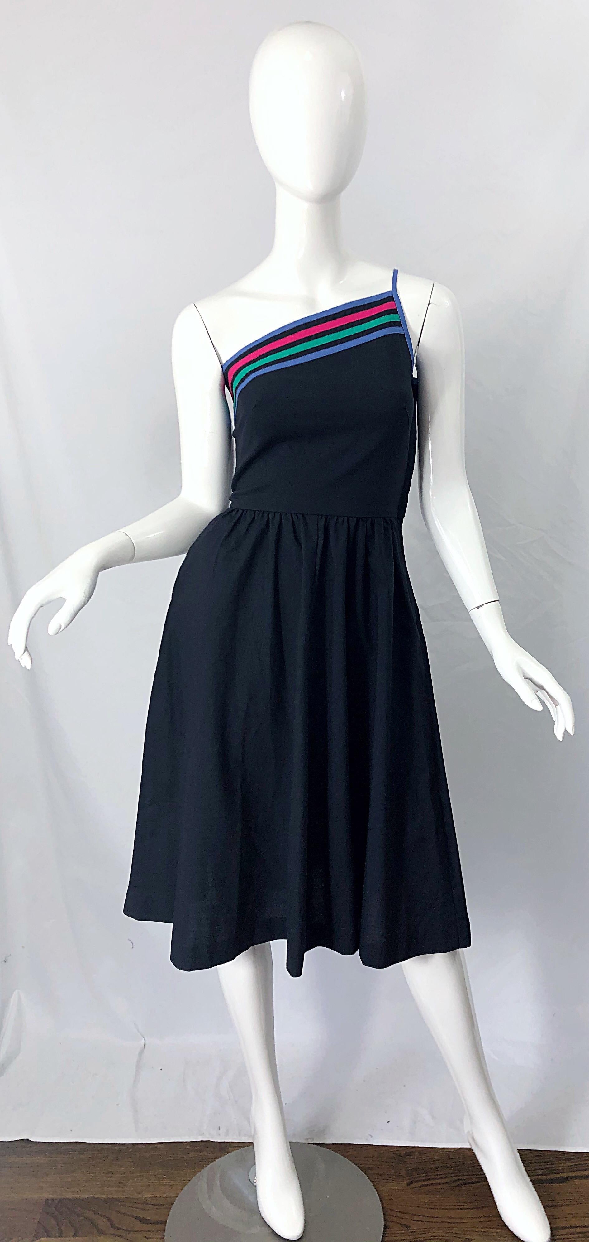 Chic vintage 80s does 50s black one shoulder fit n' flare cotton dress ! Features a tailored bodice with raspberry pink, green and periwinkle blue stripes on the top front and back. Pocket at right hip. Full skirt also allows room for a crinoline