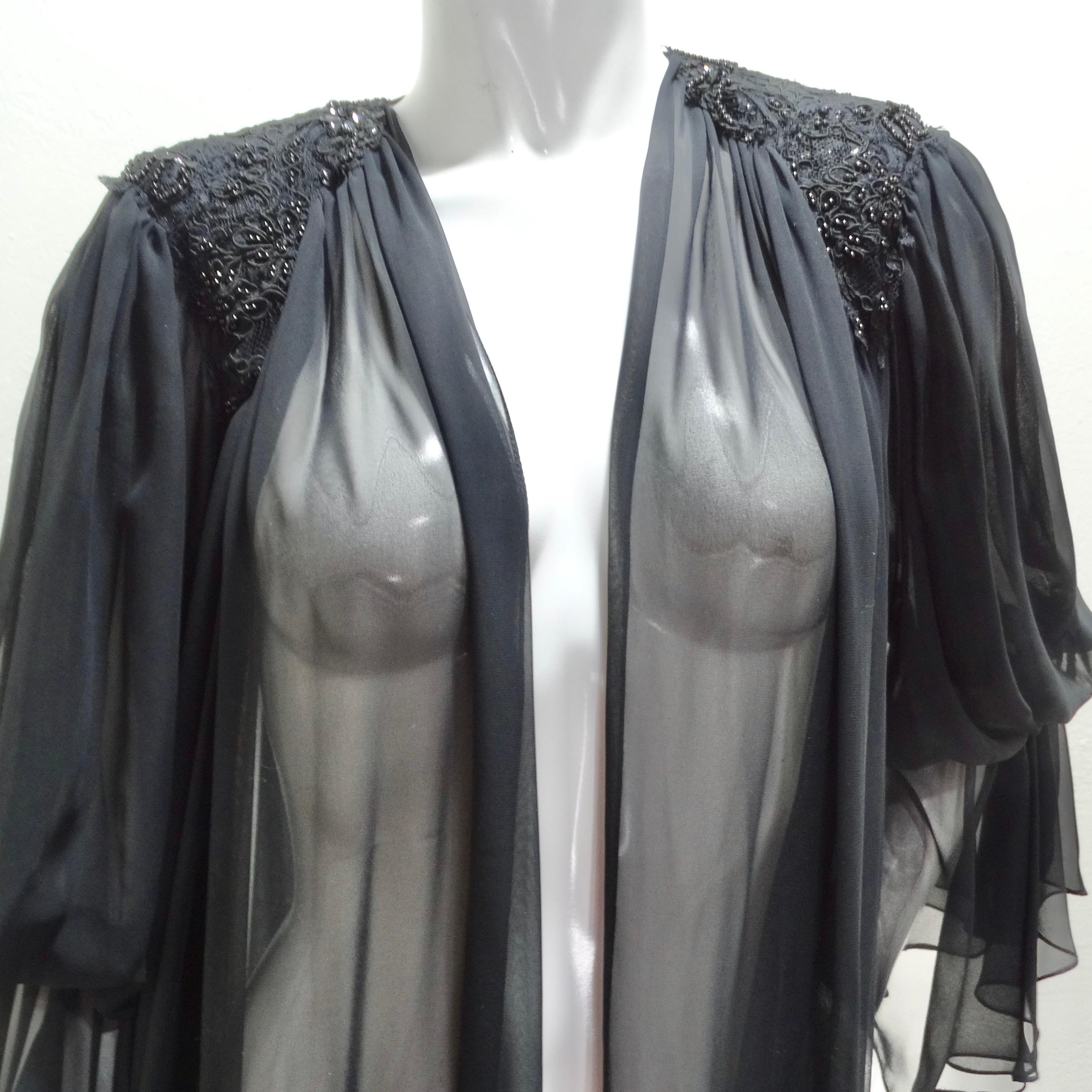 Introducing the 1980s Black Sheer Embellished Robe – a gorgeous and statement-making piece that exudes vintage charm and luxury. This robe is crafted from a black silky sheer fabric, featuring stunning billowing sleeves and intricate black bead
