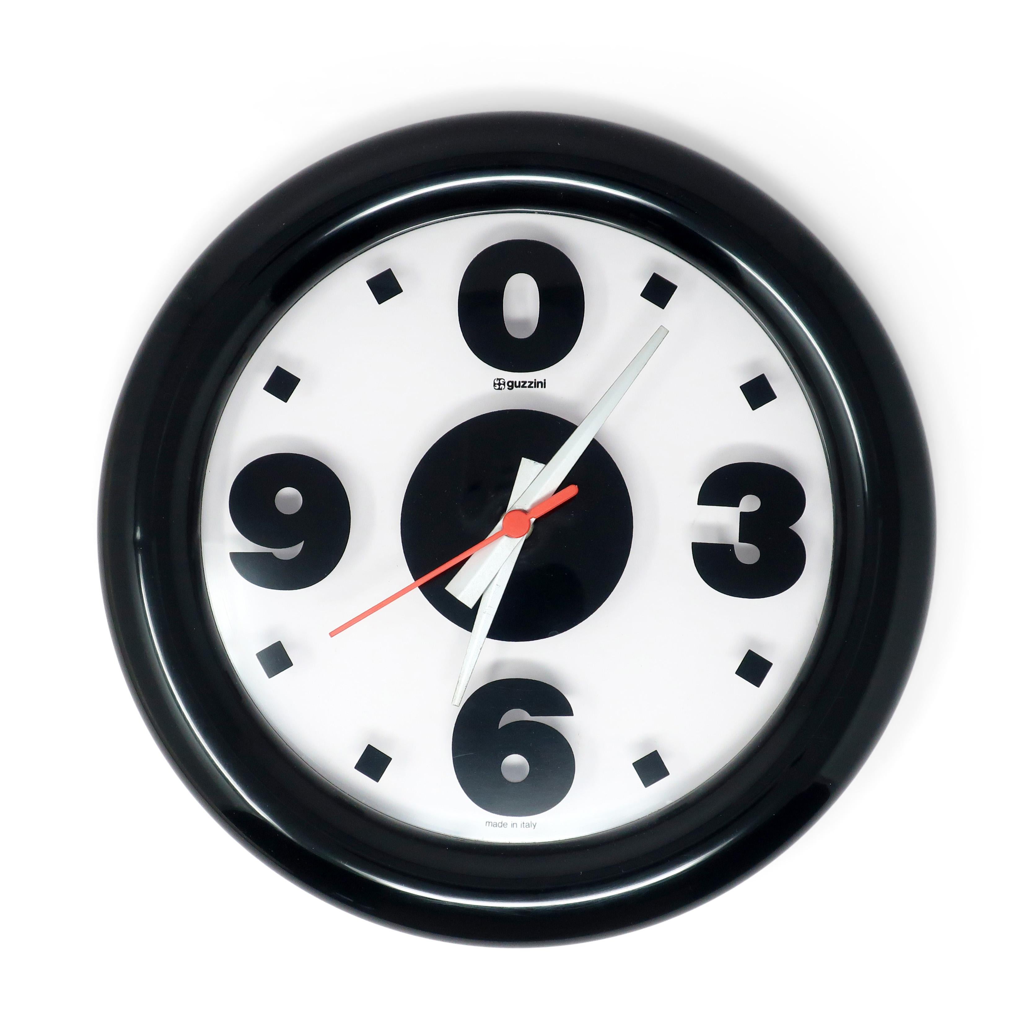 Italian postmodern design as its cleanest, this 1980s Guzzini wall clock has a black plastic body, clear lucite face, black numbers, and white and red hands.  A close to perfect design!

In good vintage condition with light wear consistent with age