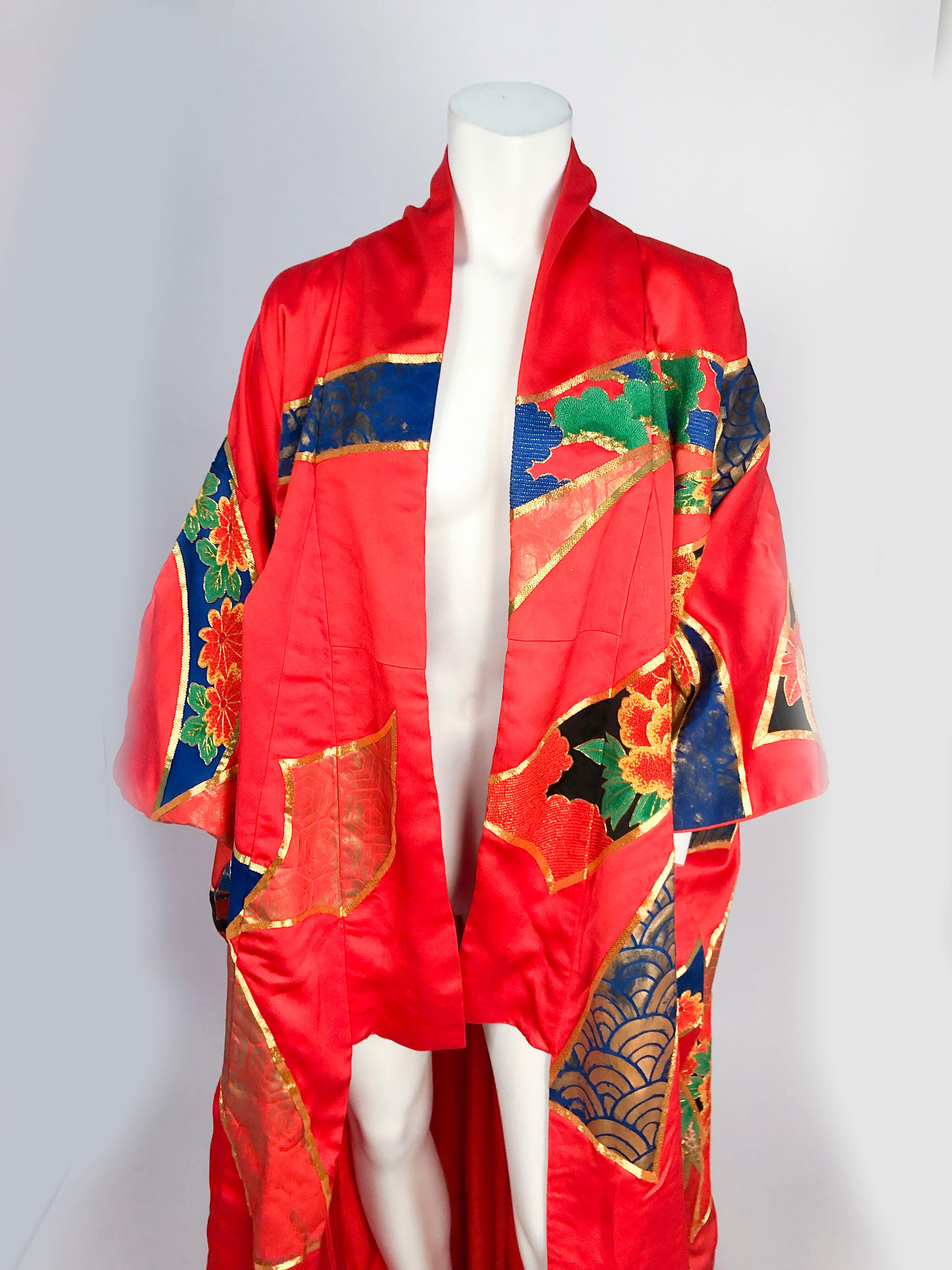 1980's Brilliant Orange Kimono Opera Coat with quilted hem that trains at the end, floral embroidery containing metallic threads, traditional Japanese long panelled sleeves, and gold stenciling.

This kimono has the following measurements:

Across