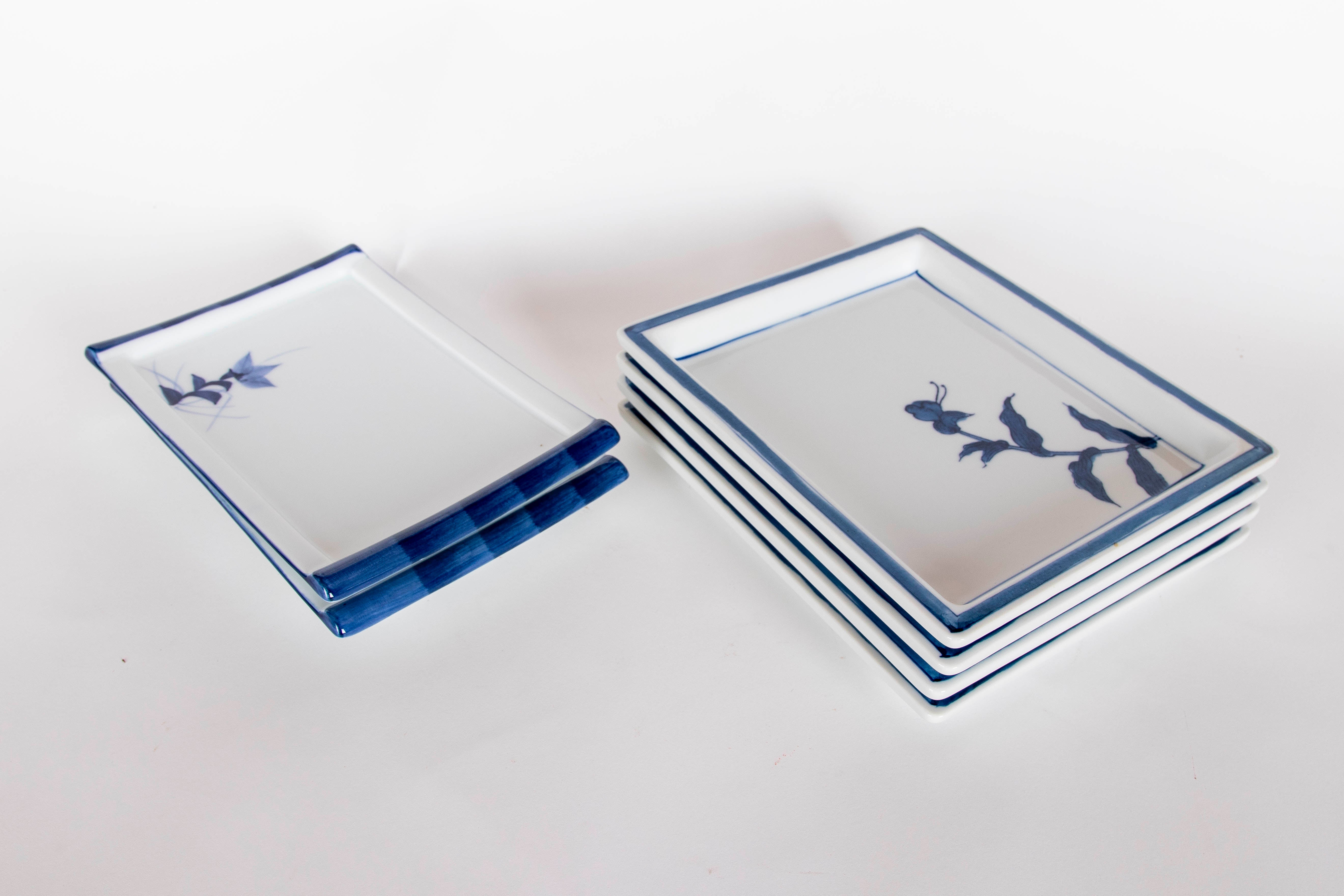 Reihe von rechteckigen Porzellantellern in Blau- und Weißtönen dekoriert. Jeder Teller zeichnet sich durch ein minimalistisches Design mit handgemalten botanischen Motiven aus, die sich durch ihre Schlichtheit und Eleganz auszeichnen.

Der Rand ist