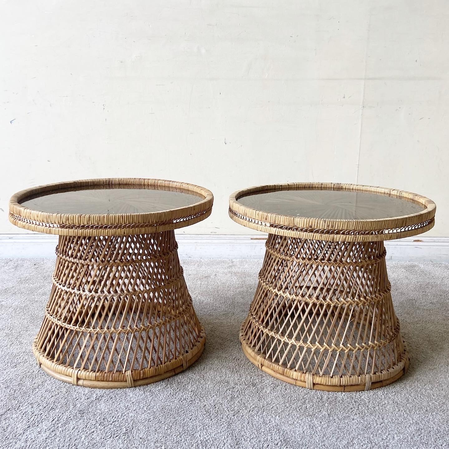 Incredible pair of vintage bohemian hour glass buri rattan side tables. Each circular table features an inlaid smoked glass top.
  