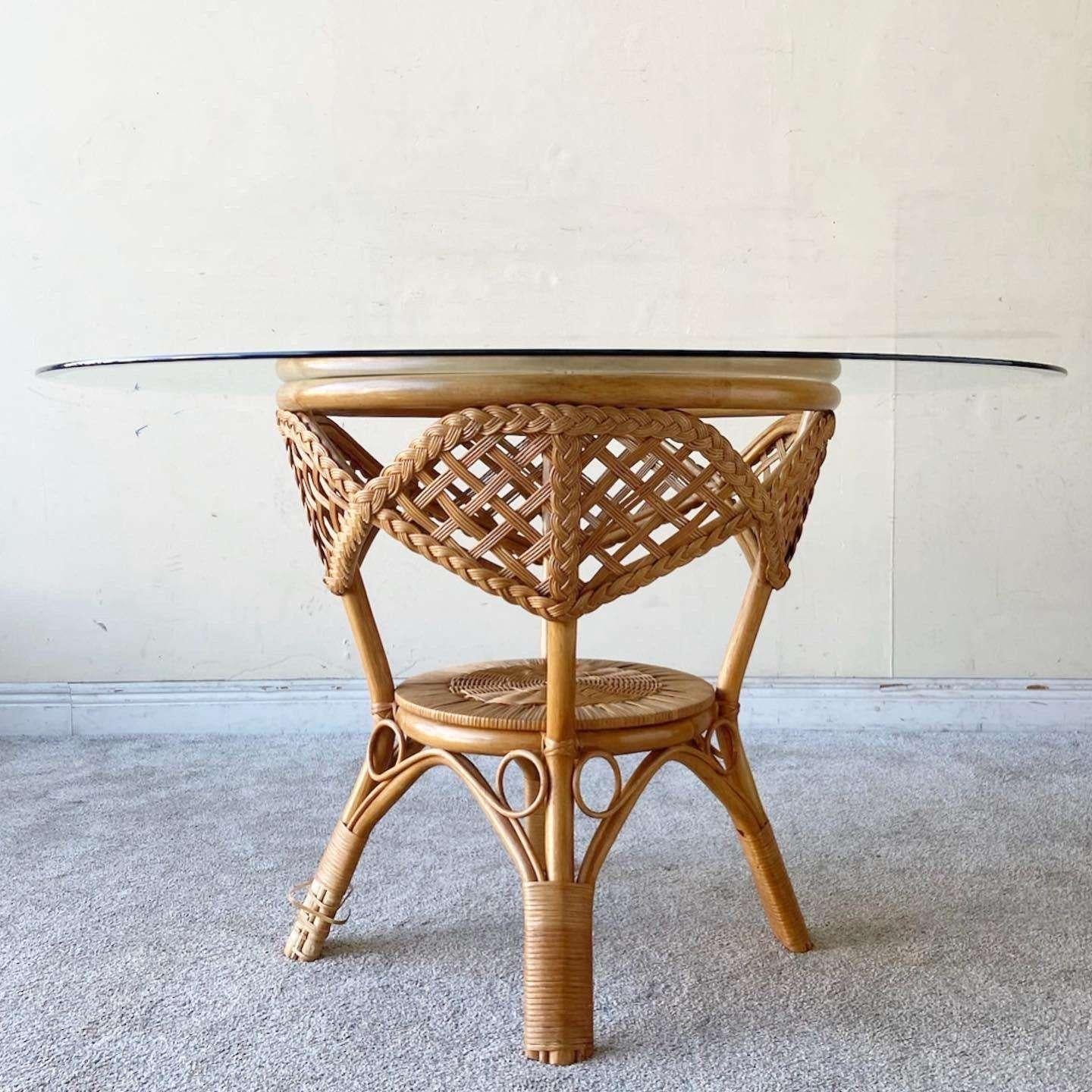 Exceptional vintage bohemian circular glass top dining table. Features a bamboo rattan and woven wicker pedestal base.