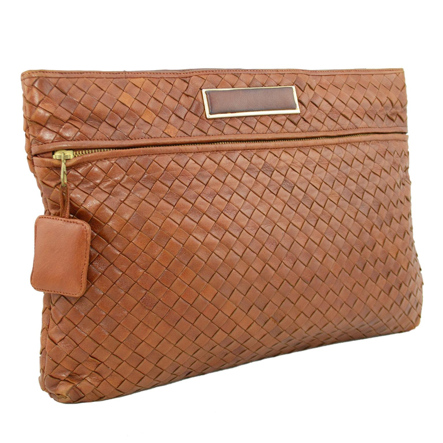 Bottega Veneta large soft clutch from the 1980s. This clutch is created from the iconic Bottega Intrecciato weaved leather in a supple saddle brown. Top fastens with a large snap button and opens to a large single compartment lined in dark brown