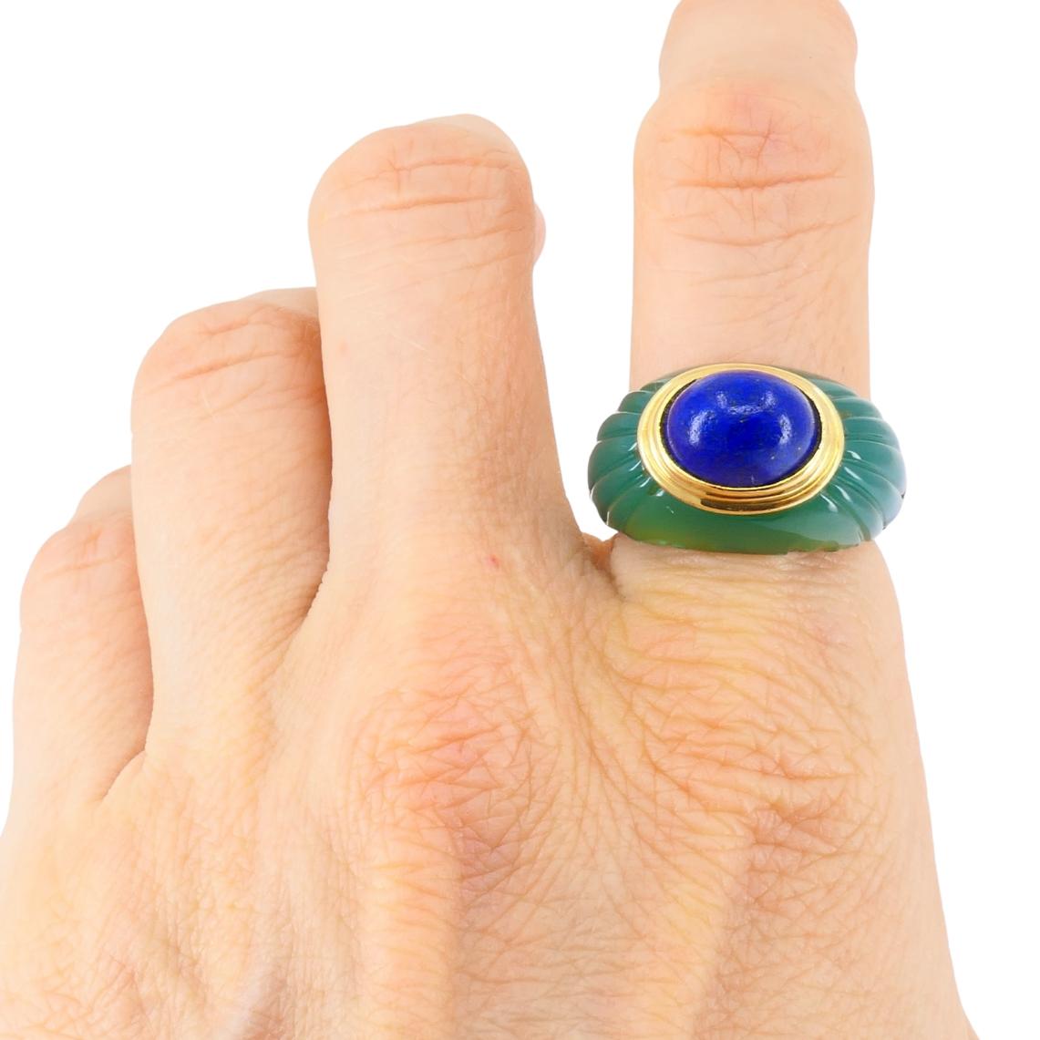 This vintage Boucheron Jaipur ring from the 1980s is a striking design that highlights the brand’s innovative use of color and form. Made in 18k yellow gold, the ring features a carved chrysoprase shank with smooth, fluted details. At the center