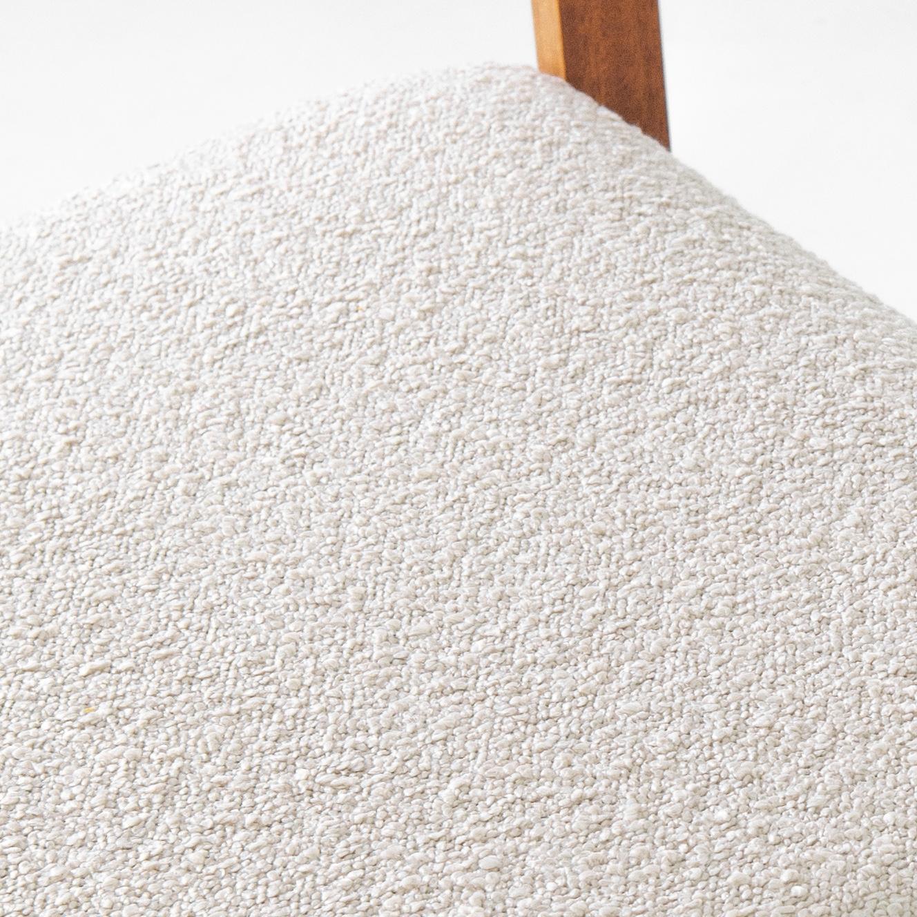 An upholstered wooden armchair with a unique Mid-Century Modern silhouette. Made in the 1980s by TON, this piece showcases the innovative yet humane design for which the Czech furniture manufacturer is renowned. Angular lines create a stylish