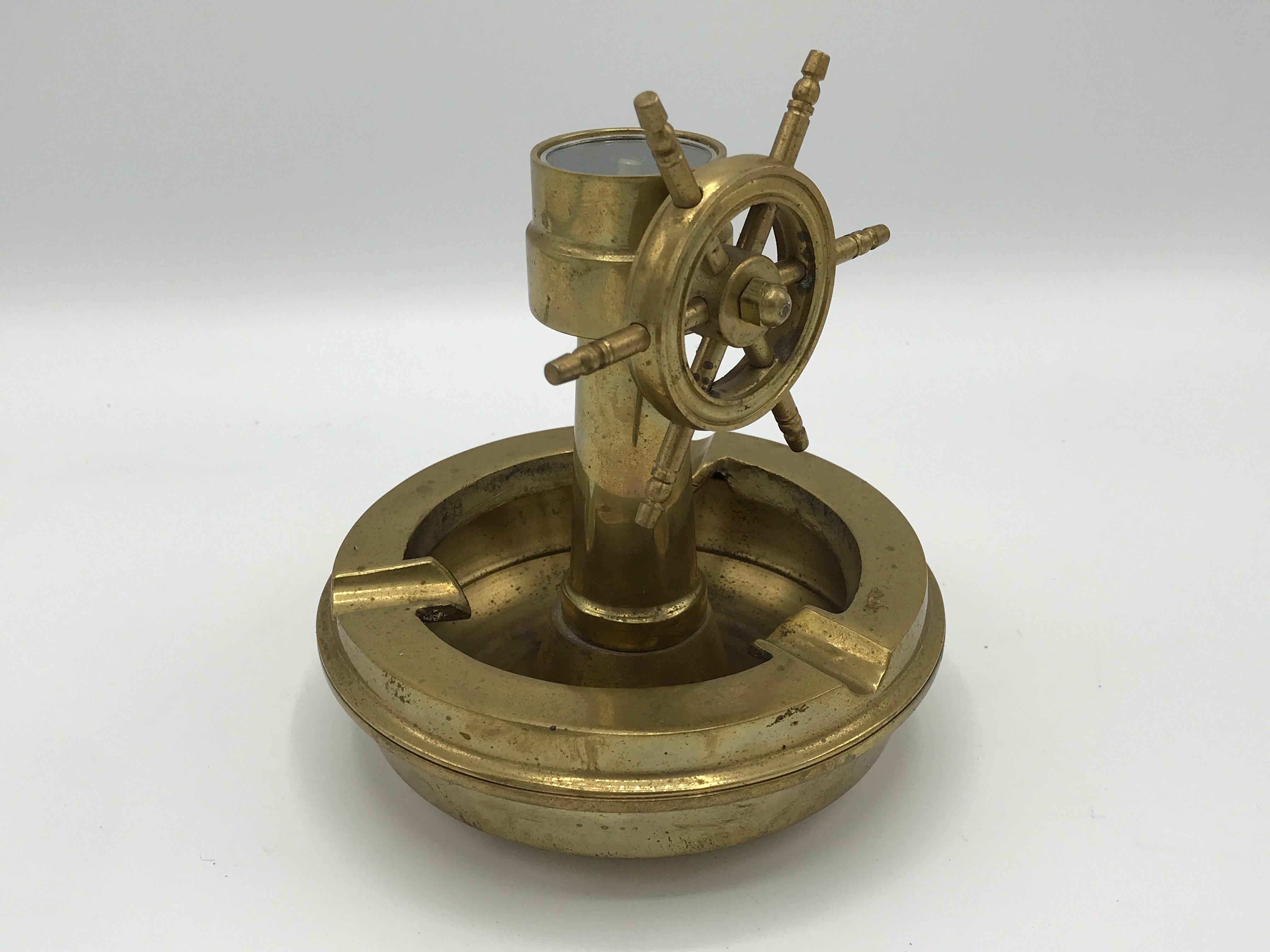 Offered is a fabulous, 1980s brass nautical ashtray catchall. The piece has a ship wheel and a working compass. The rim of the dish is removable, to convert the piece from ashtray to catchall dish. Heavy, 2lbs.