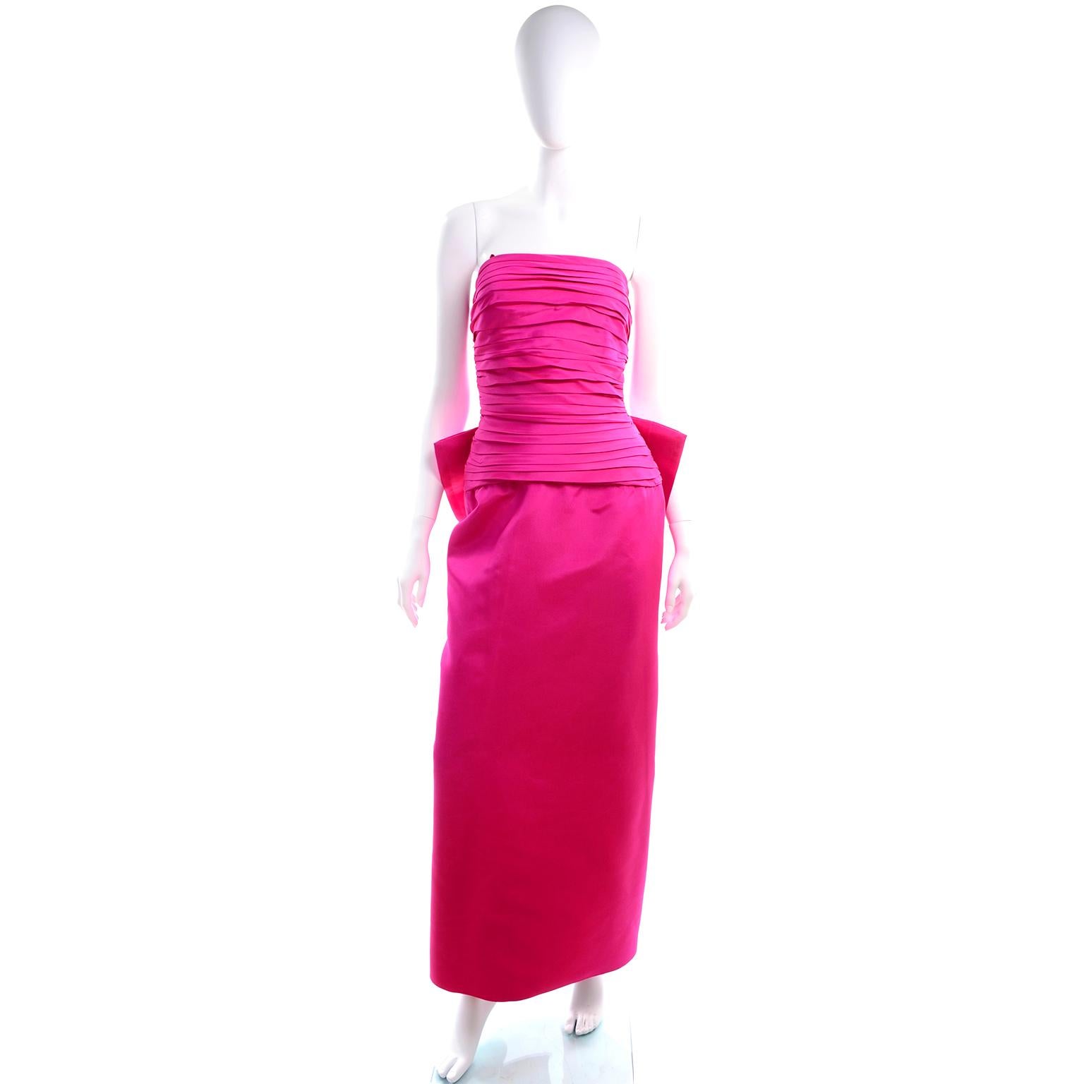 We are obsessed with this fabulous vintage 1980's evening gown!  This stunning hot pink satin dress has a dramatic bow near the small of the back and ruching on the bodice and down the seam to the hem.. The is a metal zipper down center back and a