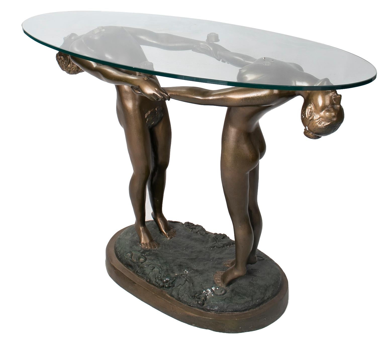 1980s bronze man and woman sculpture pedestal table with glass top.