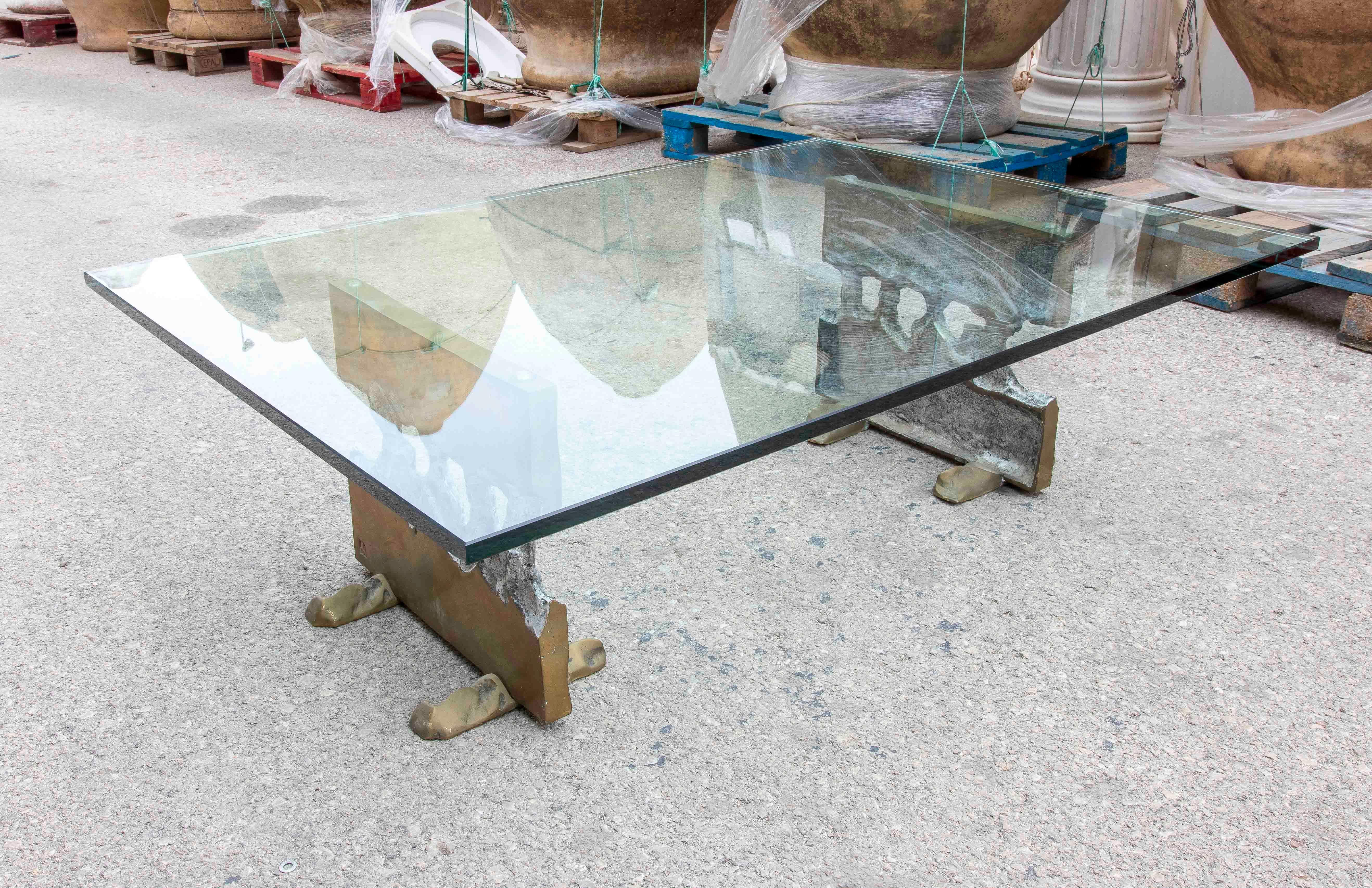 An extraordinary designer table created by renowned sculptor and designer David Marshall. The piece features a spectacular rectangular glass top resting on two cast bronze sculptural bases, with organic shapes and contrasting textures that evoke the