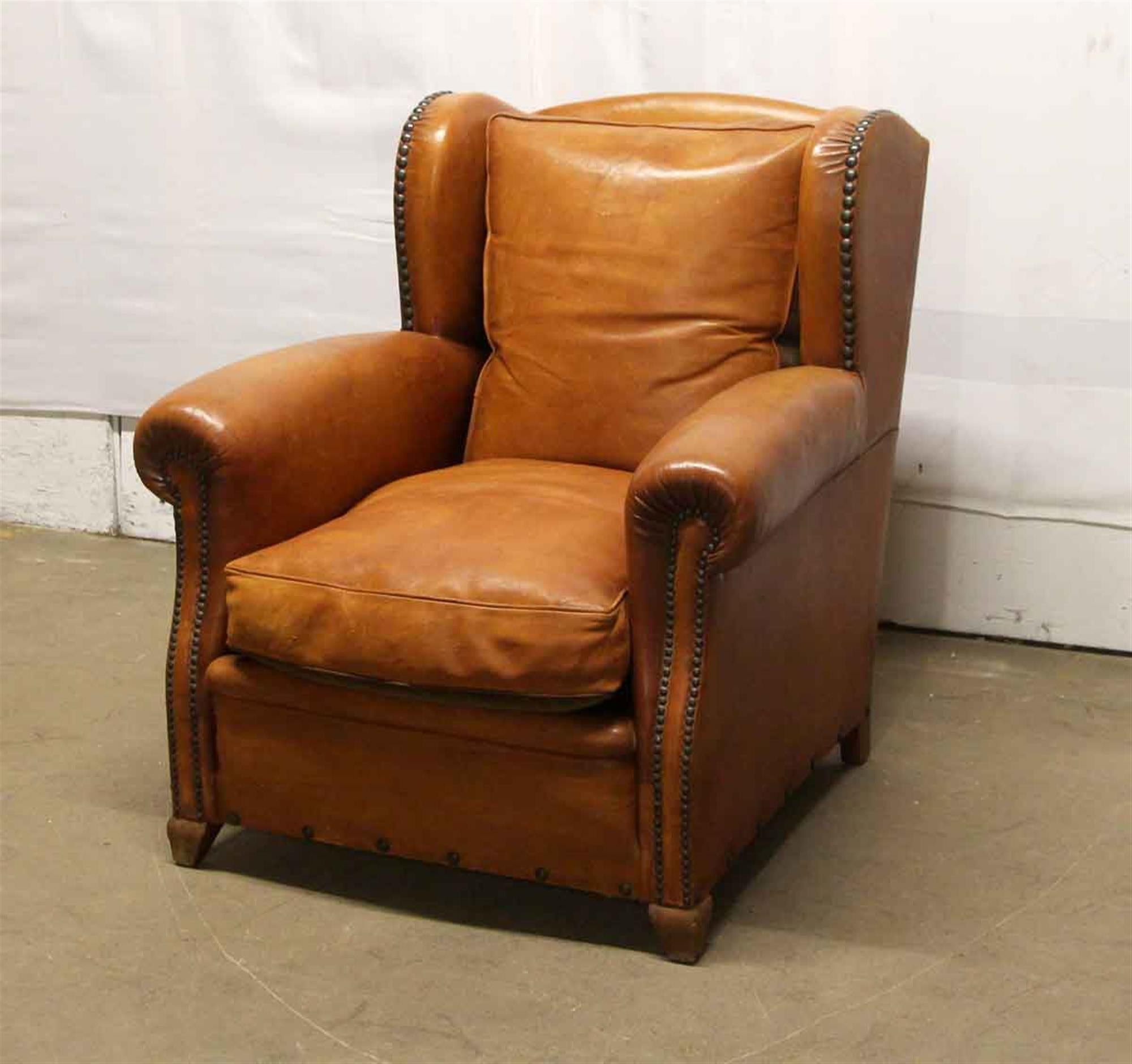 1980s French bergère leather brown club chair with studded details. This can be seen at our 302 bowery location in Manhattan.