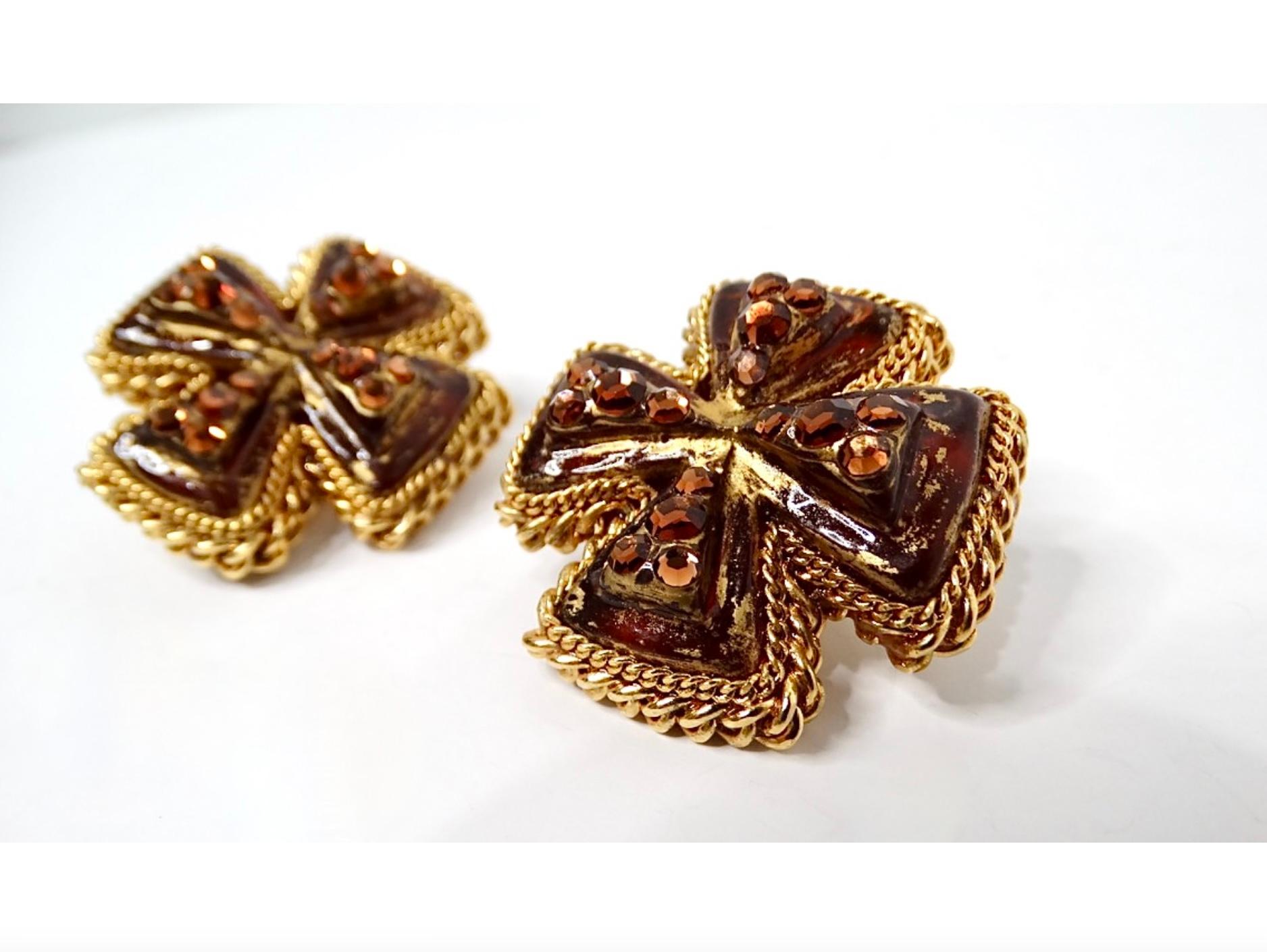 These striking 1980s Brown Resin Cross Motif Rhinestone Embellished Earrings are a perfect blend of vintage charm and bold style. Each earring features a beautifully crafted brown resin cross, elegantly framed by a gold tone braided metal design