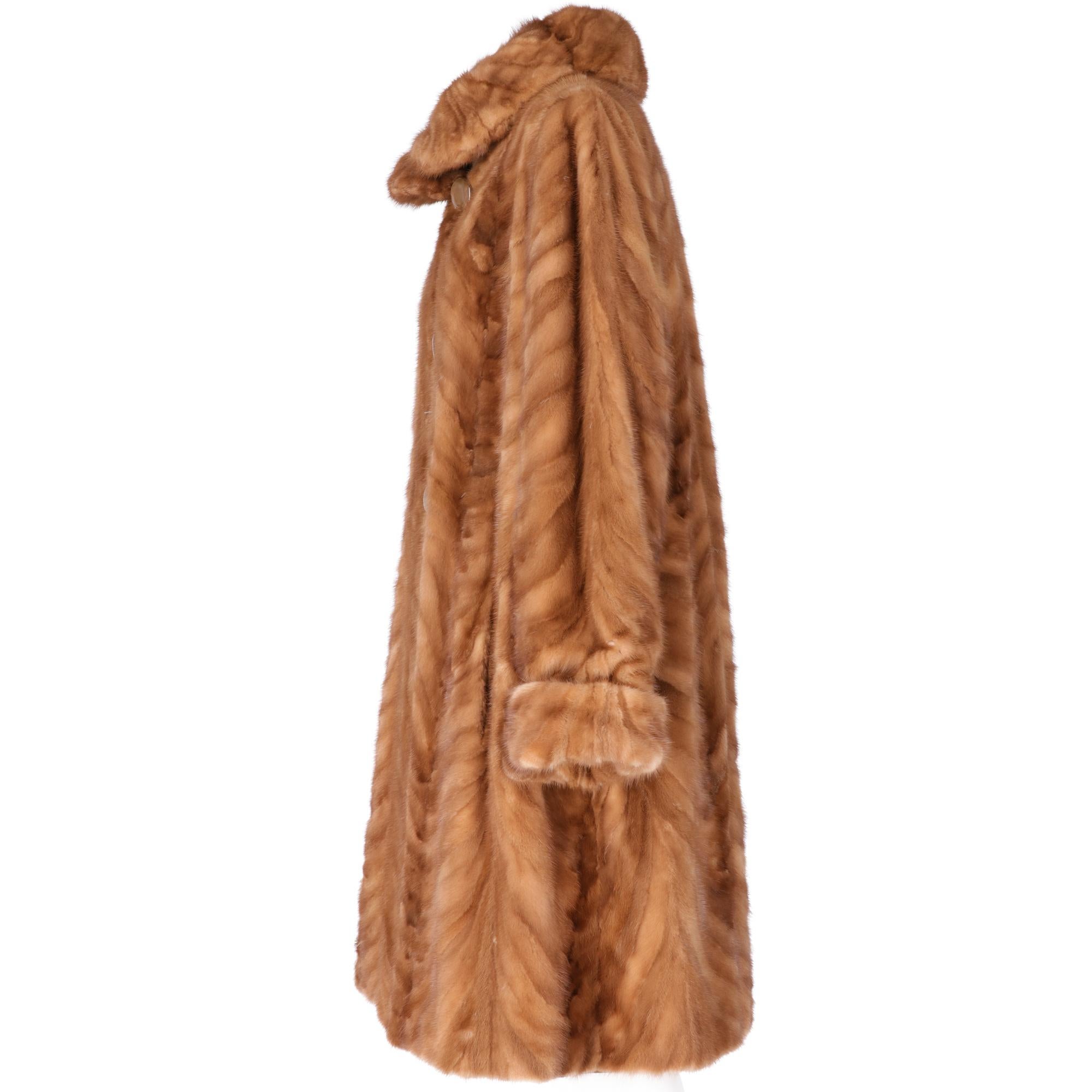Reversible brown mink fur long below the knees, with round collar. The fur side has two hidden pockets on the front, large beige hemispherical buttons, the fabric side made of bronze-colored iridescent silk taffeta with welt pockets, lacing with
