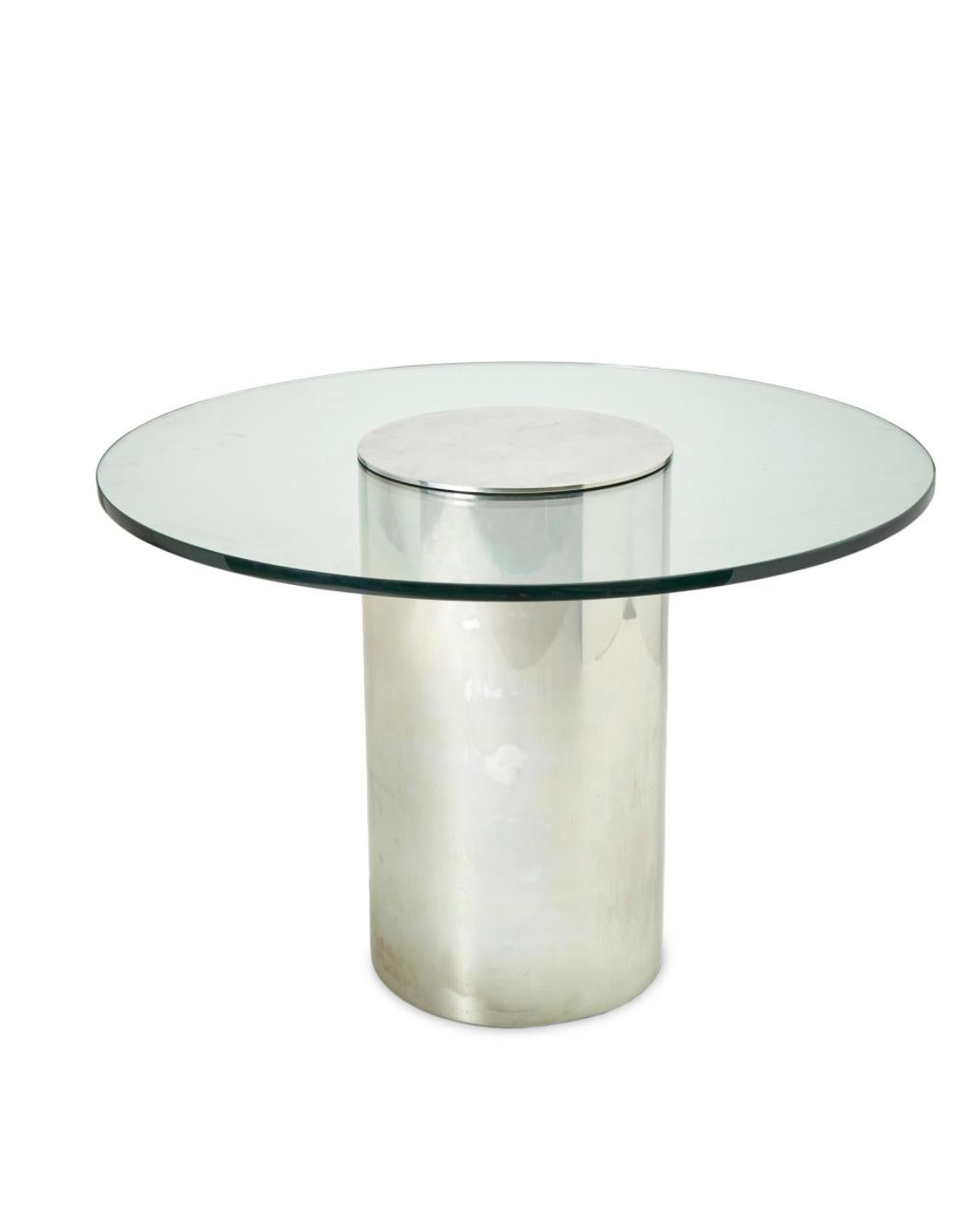 Contemporary table with a polished, cylindrical chrome base and a circular glass top. 1980s Brueton-style contemporary table with a polished, cylindrical chrome base and circular glass top. One-inch beveled glass in very good condition. The base has