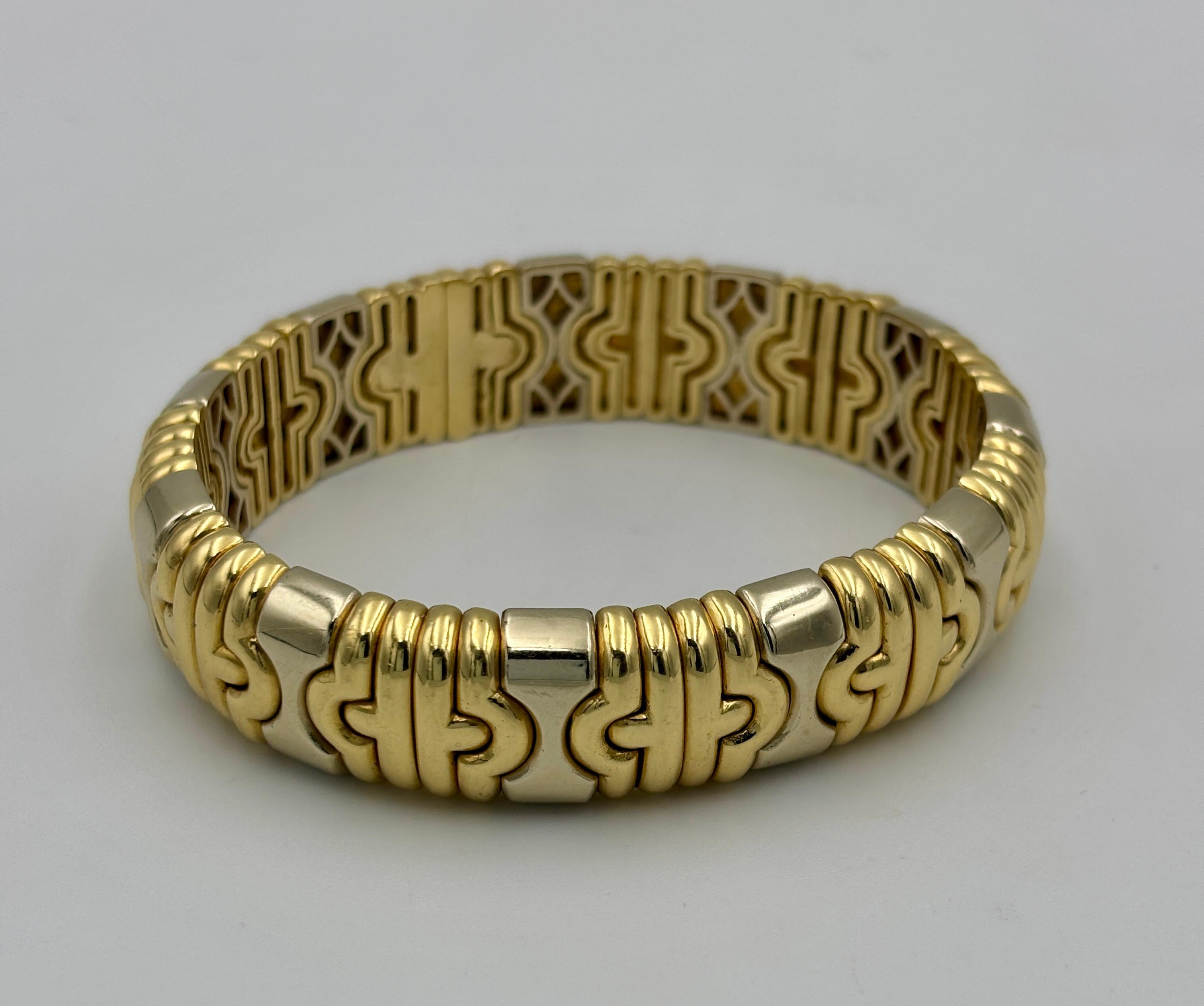 Dieser kultige Armreif aus 18 Karat Weiß- und Gelbgold von Bulgari ist flexibel und kann an Handgelenke mit einem Umfang von 16-18 cm angepasst werden. Der in den 1980er Jahren hergestellte Armreif trägt den Bulgari-Stempel sowie die Marken 
