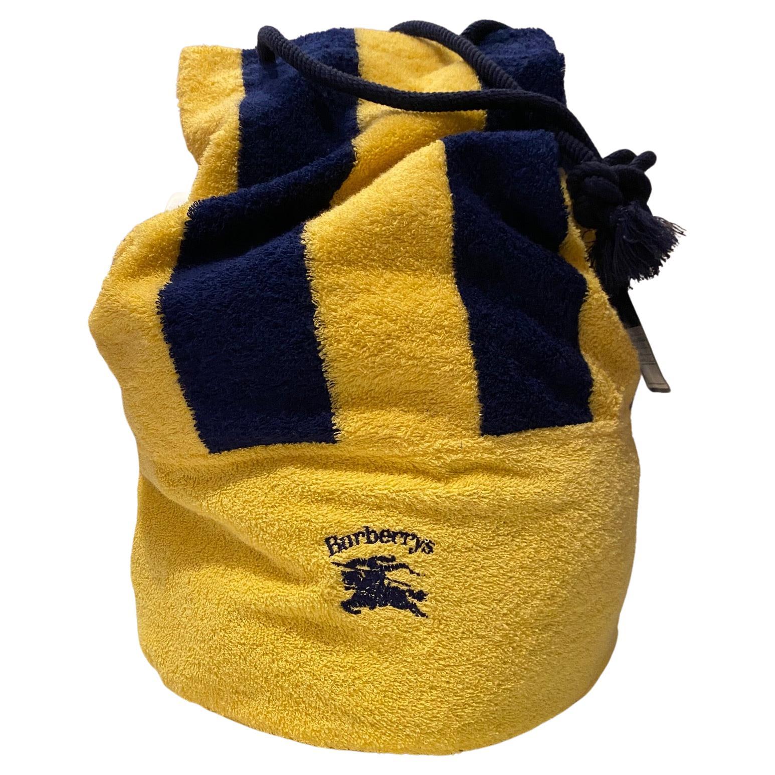 Die Burberry Toweling Beach Duffle Bag in Gelb ist mit einem Logo auf der Vorderseite und blauen Seilgriffen versehen und damit die perfekte Wahl für Ihren Strand-/Pooltag. Diese auffällige Tasche aus Frottee ist eine luxuriöse und robuste Option