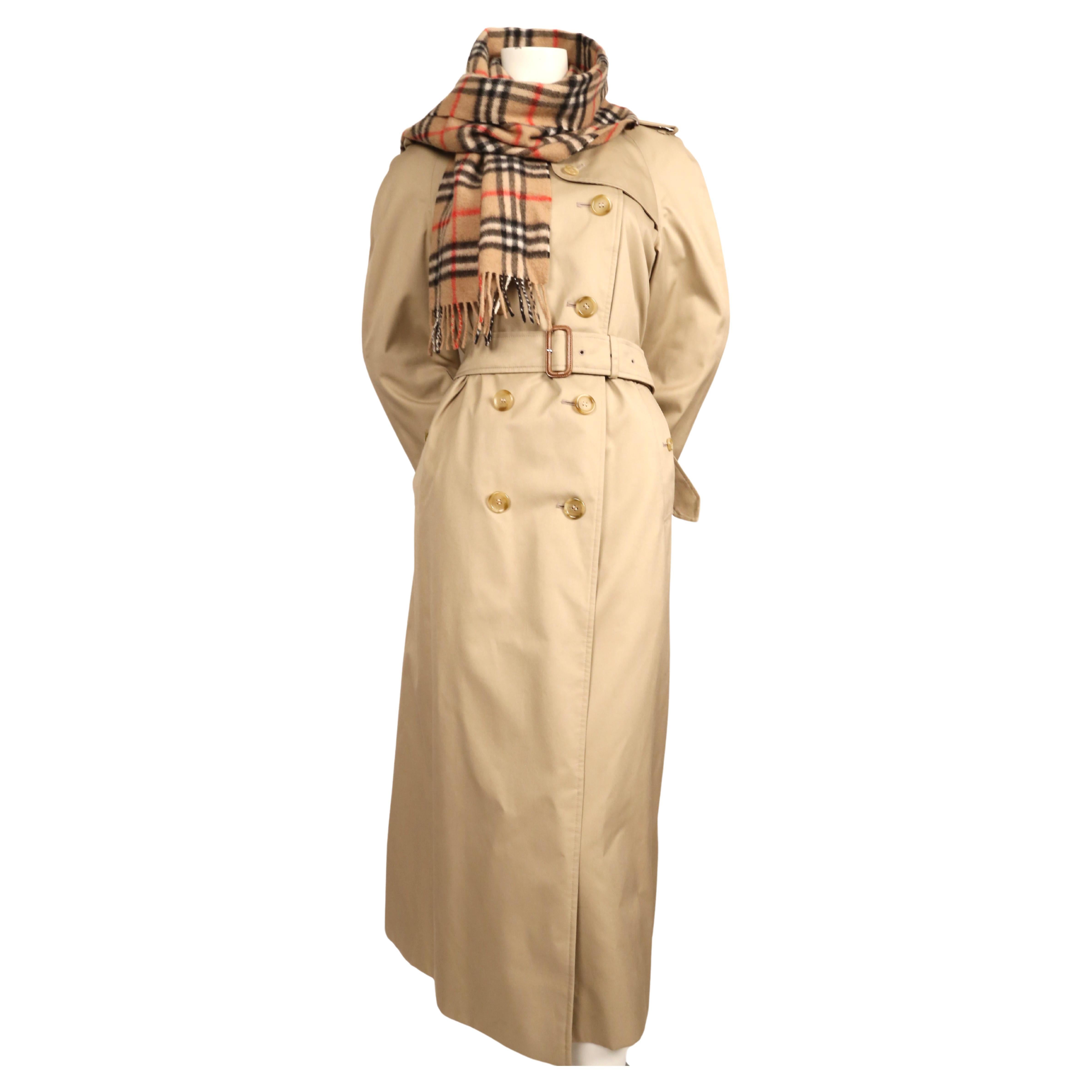 Classic, tan gabardine trench with matching nova check cashmere scarf from Burberry's dating to the 1980's. Trench has inner zip out wool liner. Labeled a size '10 extra-long'.  Approximate measurements: bust 42