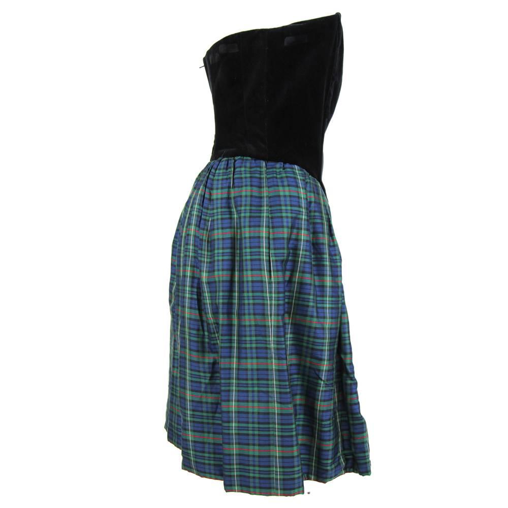Jaunty sleeveless off-the shoulders dress by Byblos with a black velvet V bodice, and a wide, soft tartan skirt in blue, green, black and red. The bodice is reinforced with flexible battens. It features a zip on the back. The dress is in very good