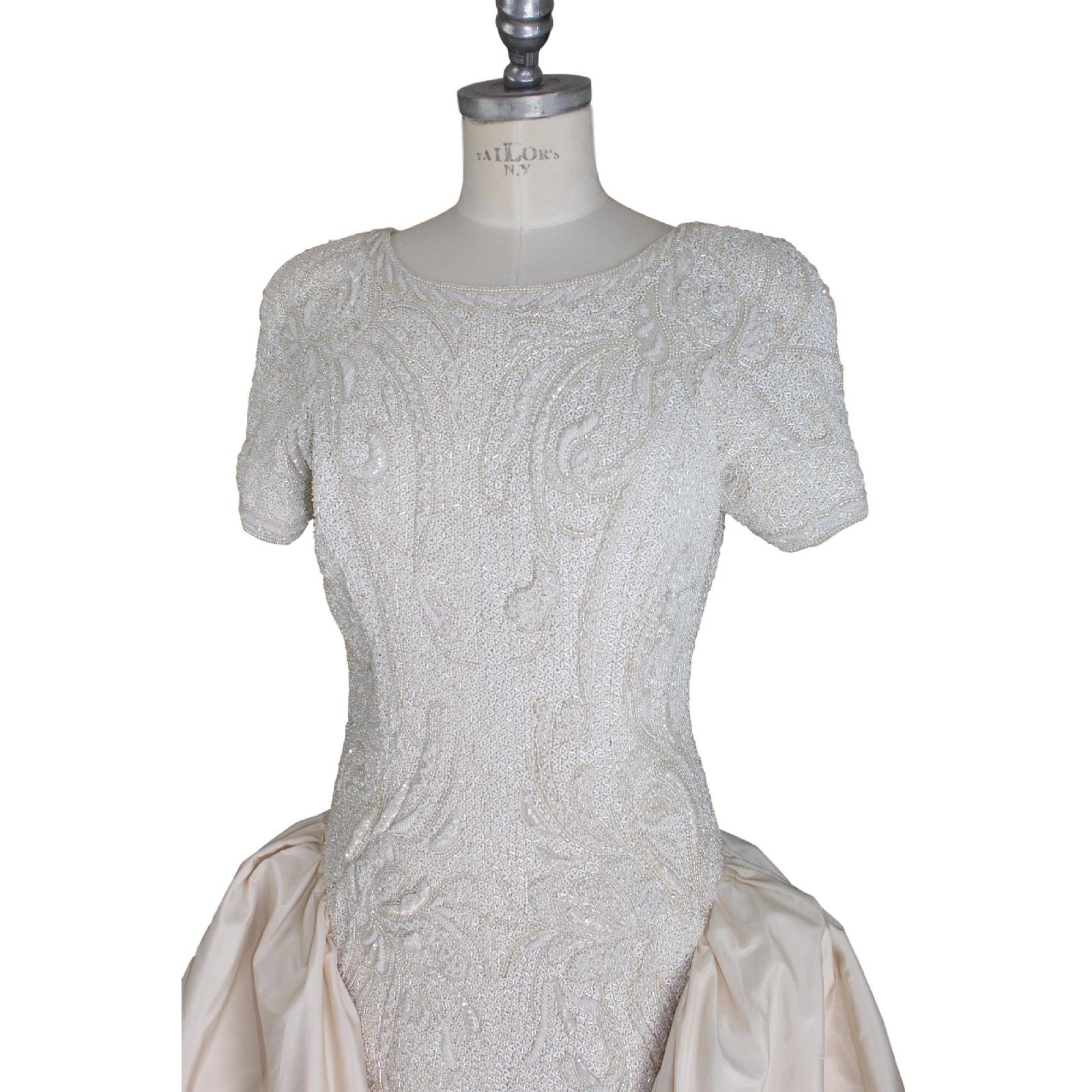 Cailan'd vintage wedding dress with short sleeves pearl and sequins whit floral motifs, has a long tail that starts from the back of the shoulder.

Used for fashion shows, not worn during marriage. It needs to be washed in professional