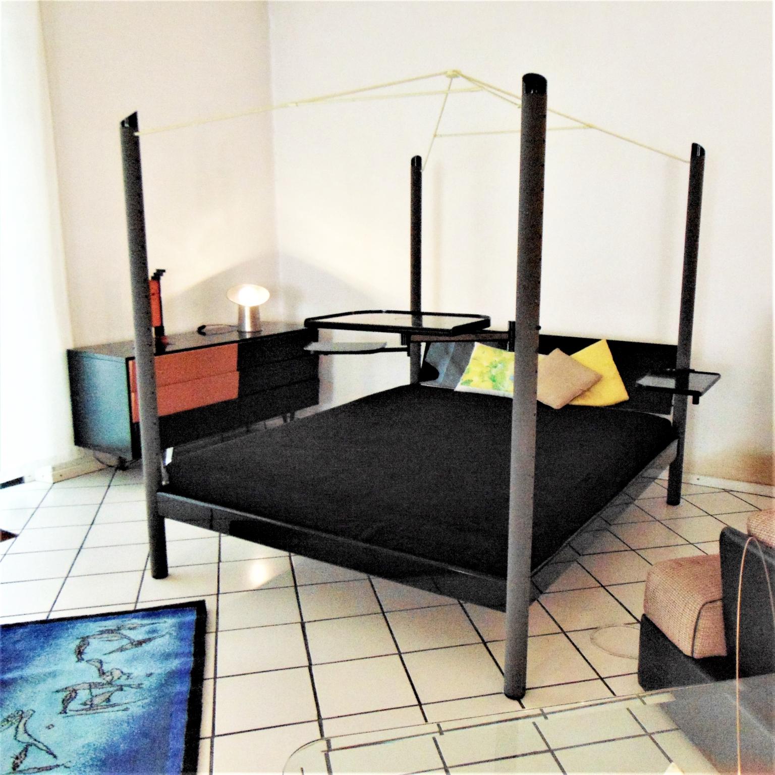 Himmelbett
Ein ungewöhnliches Himmelbett, genannt Fauno, hergestellt von Sormani in sehr dunkelgrünem (fast schwarzem) Glanzlack, mit 4 Säulen in grauem Nextel und einem Metallhimmel in hellem Apfelgrün. Das Bett verfügt über multifunktionale