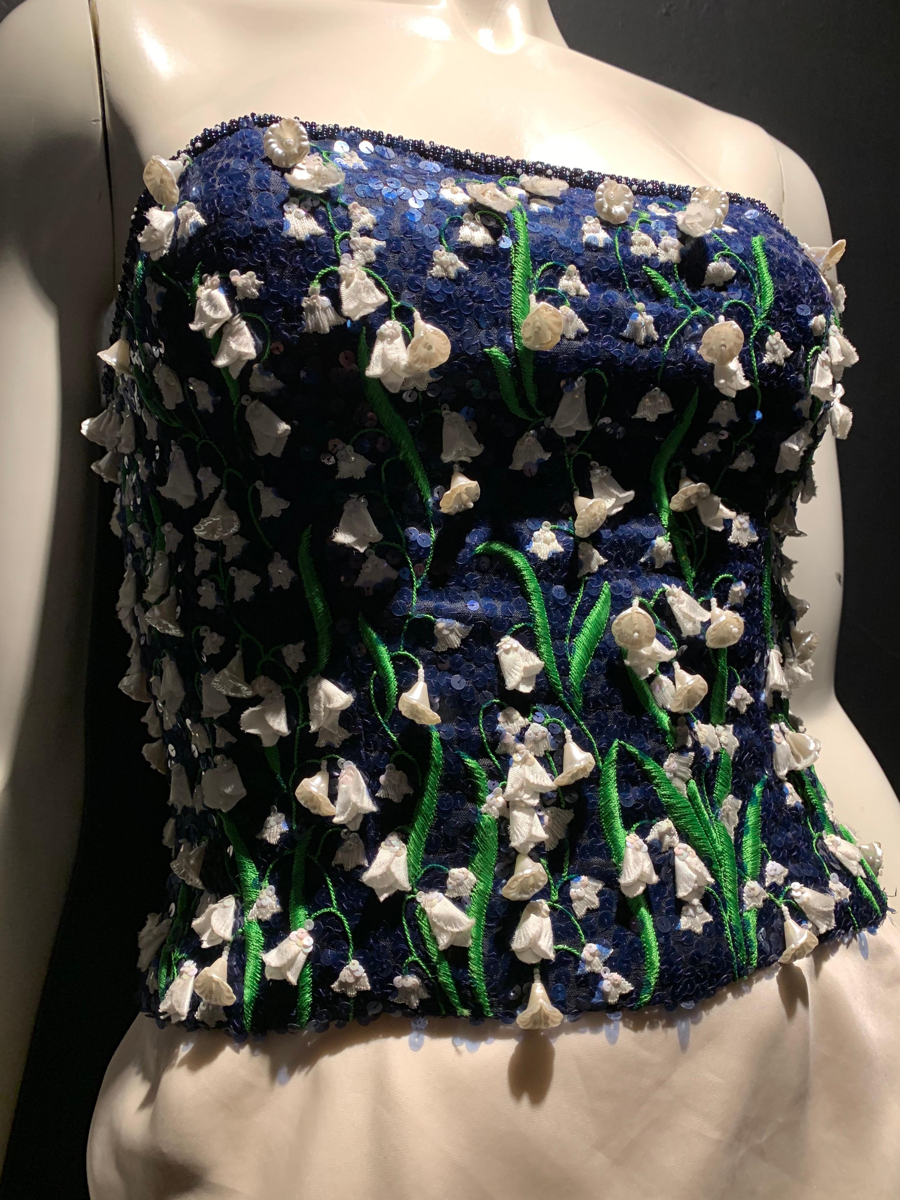 1980s Carolina Herrera lily of the valley embroidered and sequined, navy blue, boned strapless bodice cocktail mini dress with plastic blossoms. 3-layer organza piped skirt. Size 6.