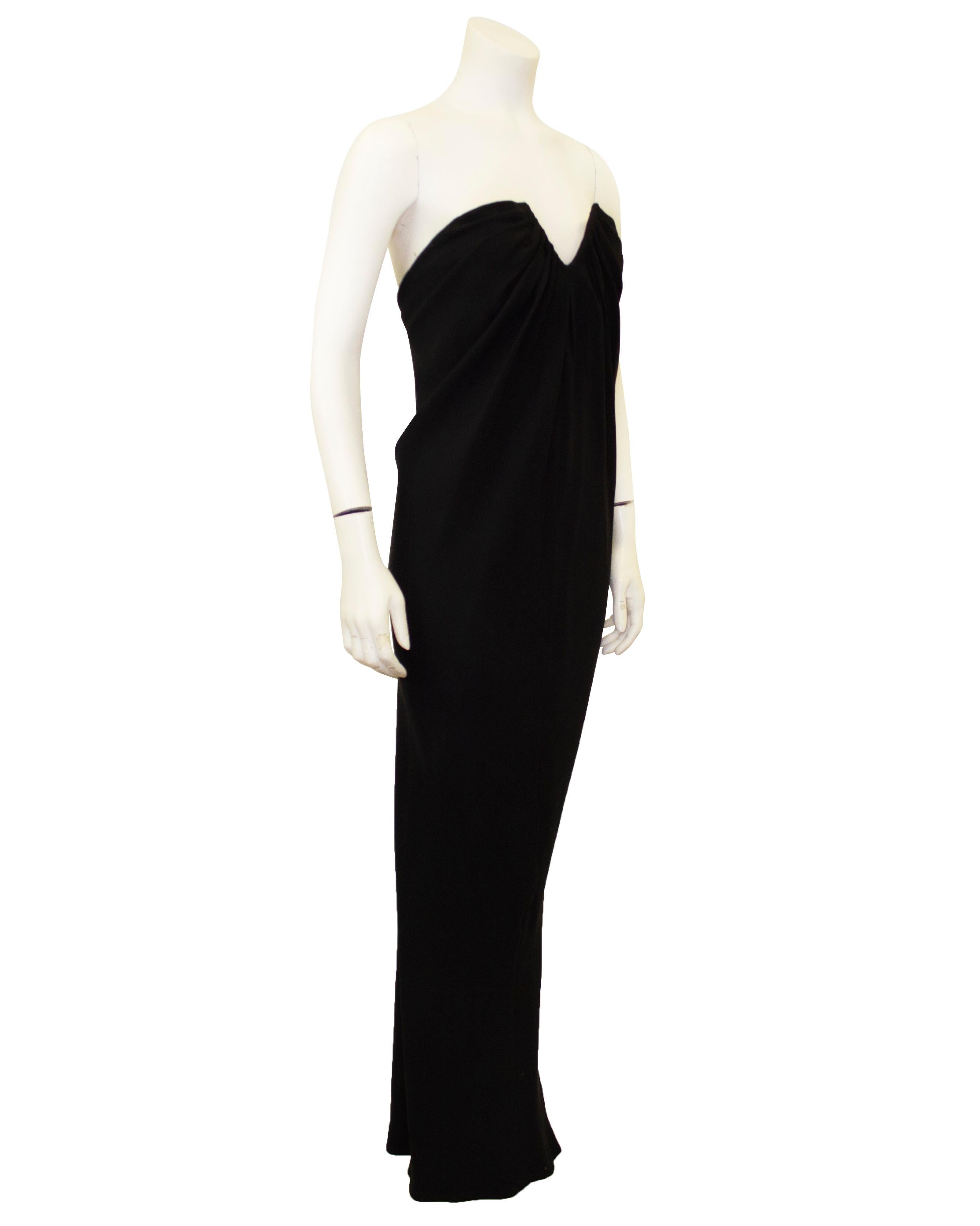 Sleek and sexy Carolyne Roehm black silk gown from the 1980s. Strapless with a u shaped cut out at the bust. The fabric ruches around the cut-out creating outward draping. Skirt skims the body and tapers at the bottom in a slight cocoon shape.
