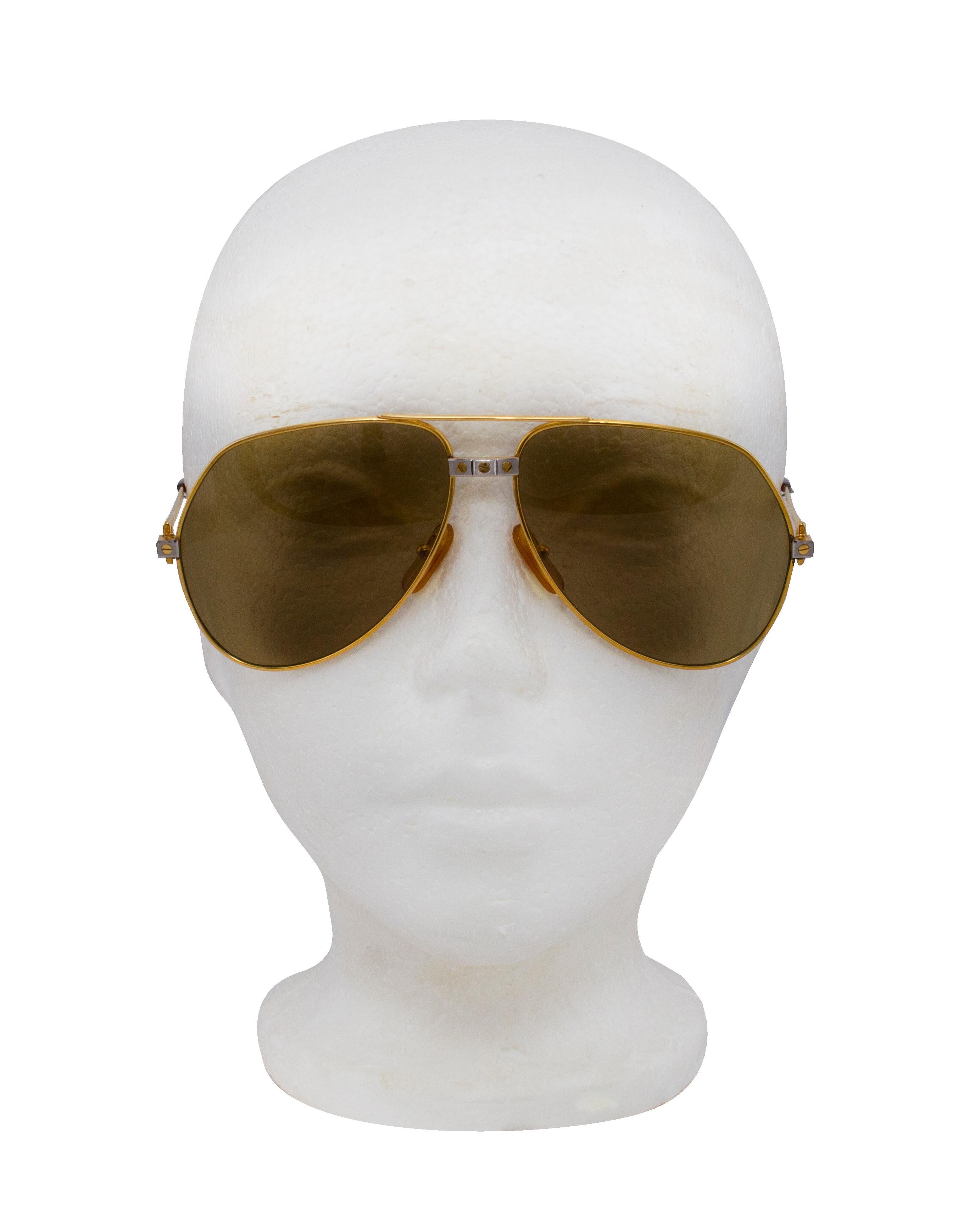 These Cartier aviators are the ultimate pair of vintage sunglasses. Dating from the 1980s, these are the Romance Santos aviators. Gold frame and arms with Cartier screw details on the bridge and temples in a mix of silver and gold. A backwards 'C'