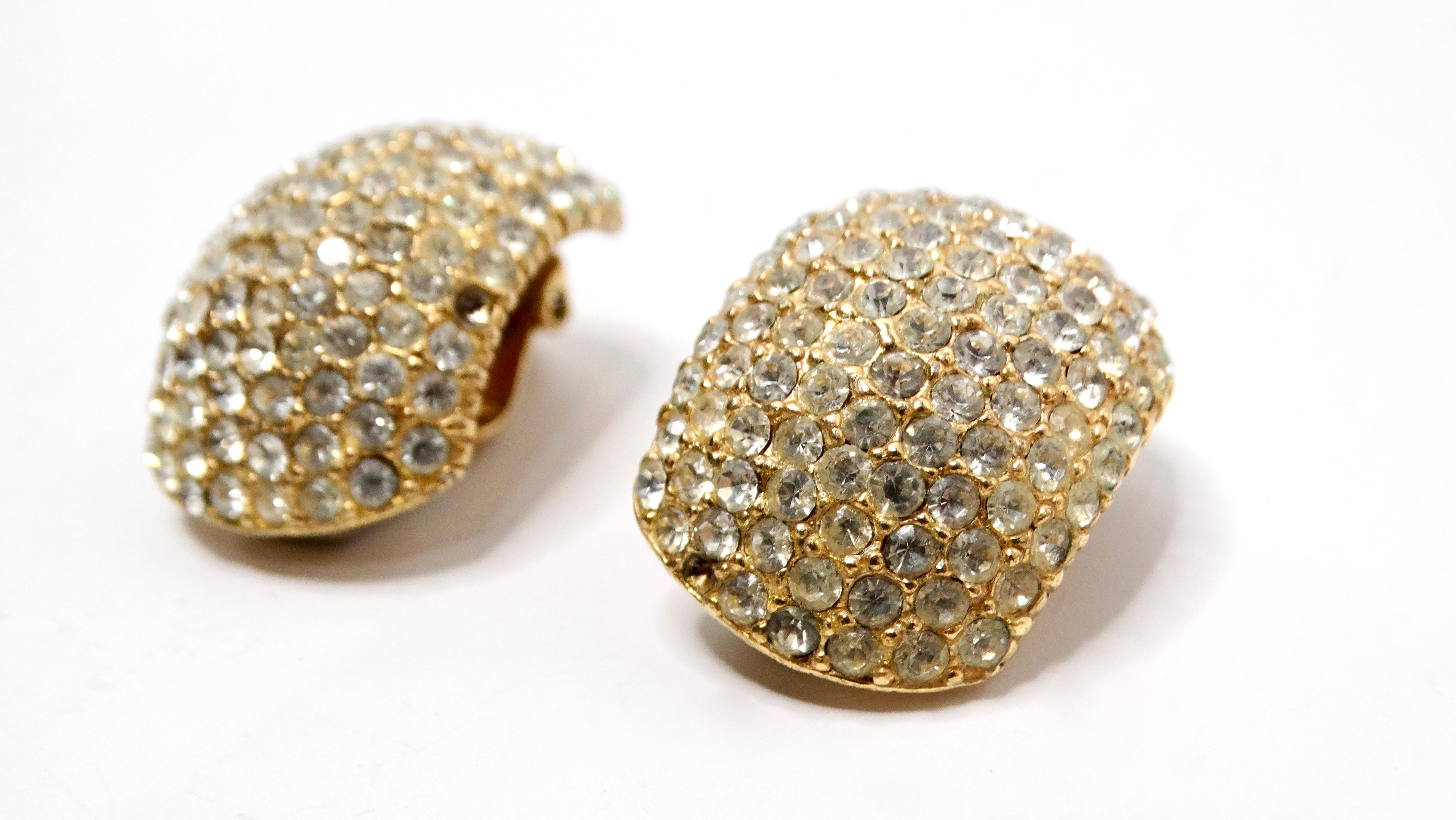 Introducing a stunning pair of 1980s Cartier-inspired Ciner earrings, beautifully crafted with a luxurious 14k gold plating and adorned with eye-catching rhinestones. These curved clip-on earrings exude an air of vintage sophistication, making them