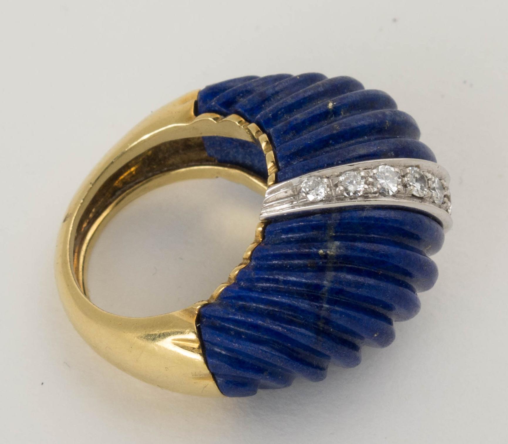 A large and impressive 1980's carved lapis lazuli dome ring set in 18K yellow gold and accented with diamonds.
The high dome of the ring crafted of two sections of carved, deep blue lapis lazuli. The lapis sections joined by a band of 11 round