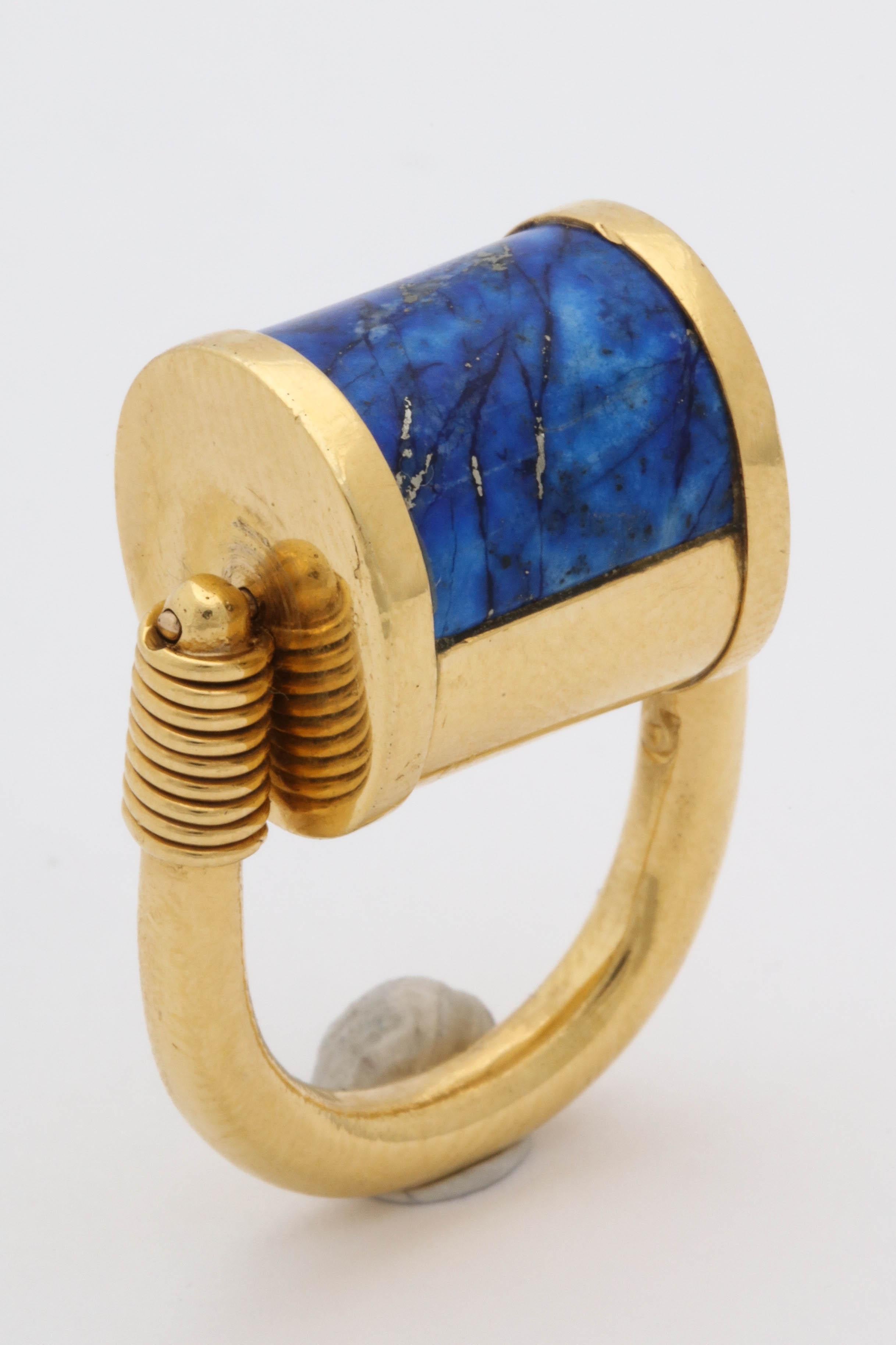 One Unisex Unusual Padlock Design Rolltop Reversible Ring Composed Of One Custom Cut Inlaid Lapis Lazuli Stone.This Three Dimensional Ring May Be Rolled Over To Wear On The Gold Side. Ring Created In 22kt Gold Designed By Cellini Jewelers.Current