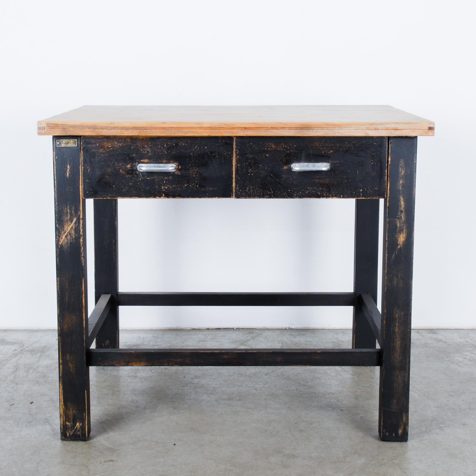 A black patinated wood occasional table from Central Europe, circa 1980. Great for a studio or working space, its double drawers with metal pulls makes it a perfect side table. Bold, heavy furniture started to make a comeback in the 1980s, here