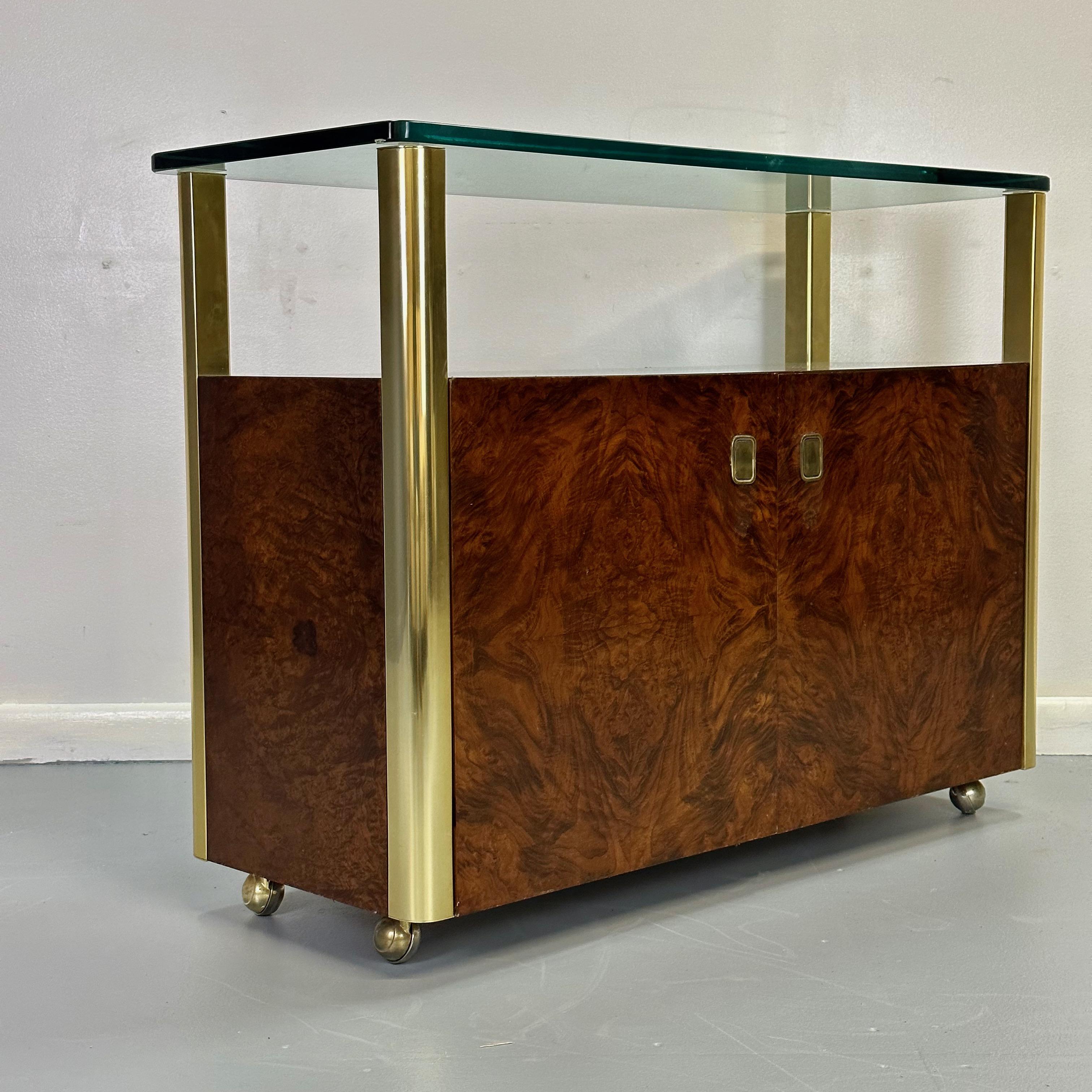 Vintage burl wood and brass bar cart designed and manufactured by Century Furniture Company in the United States, circa 1970's. This fabulous bar car features a thick glass top that sits over four brass columns, and a burl wood cabinet in the center