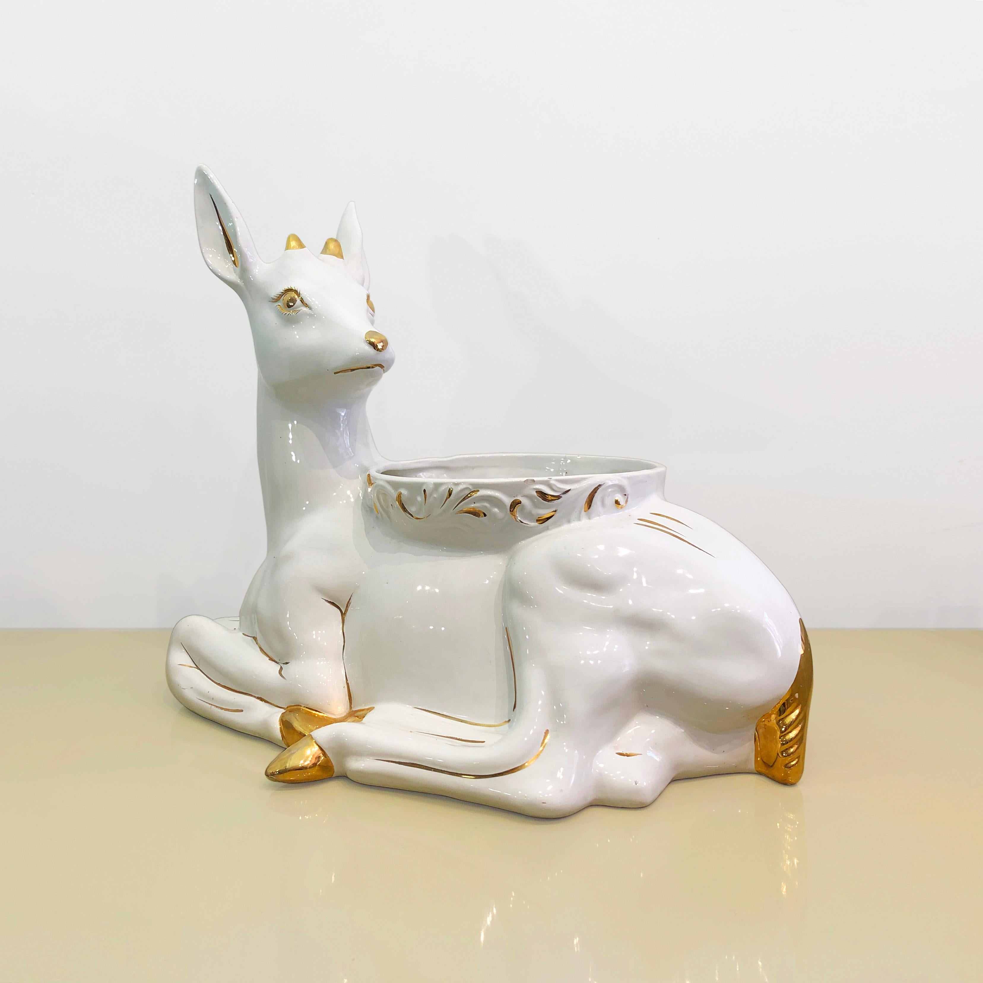 This nature inspired ceramic glazed planter by Antica Athena consists of a white deer faun with gold plated detailing. This faun brings in mind the nature and motherly love that this young deer seems to gaze at, with some humour attached to it