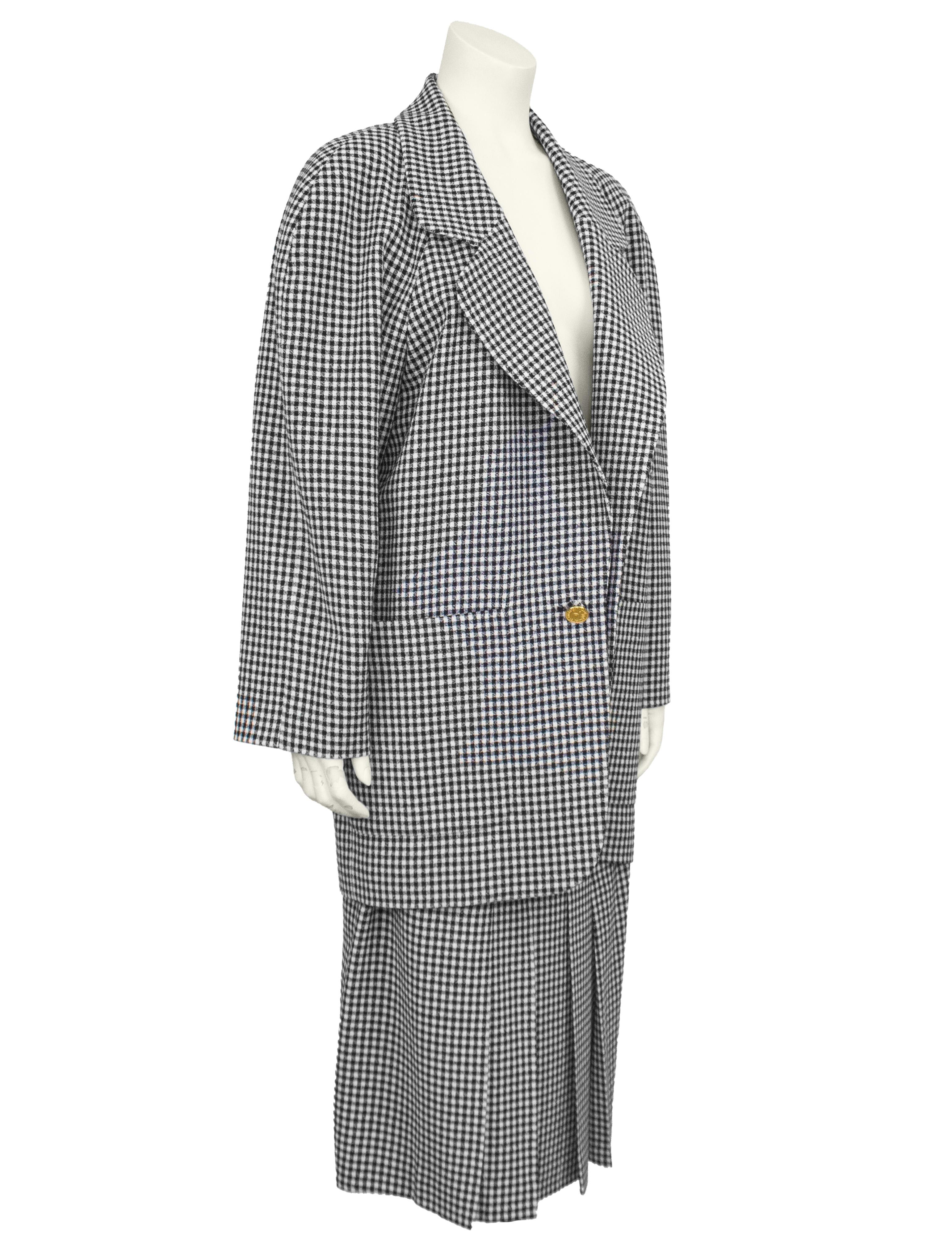 Audace completo Chanel con giacca e gonna degli anni '80. In crêpe di lana con un classico motivo a quadri bianchi e neri, l'ensemble presenta un blazer molto oversize con ampi revers a lancia, spalle padellate, ampie tasche applicate e bottoni 