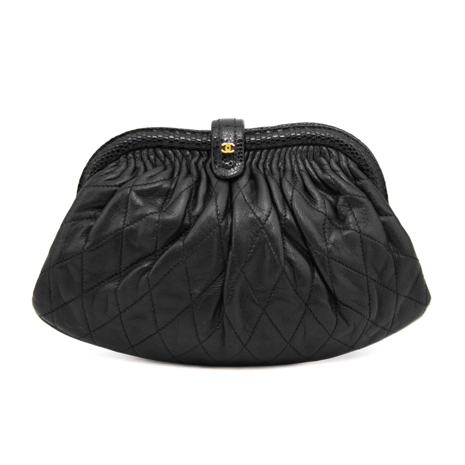 Classic framed style Chanel evening bag with long tubular chain strap. Black quilted leather with some pleating at the top of the frame and black  piping. A black skin covered top snap closure allows for easy access with CC logo on the front.