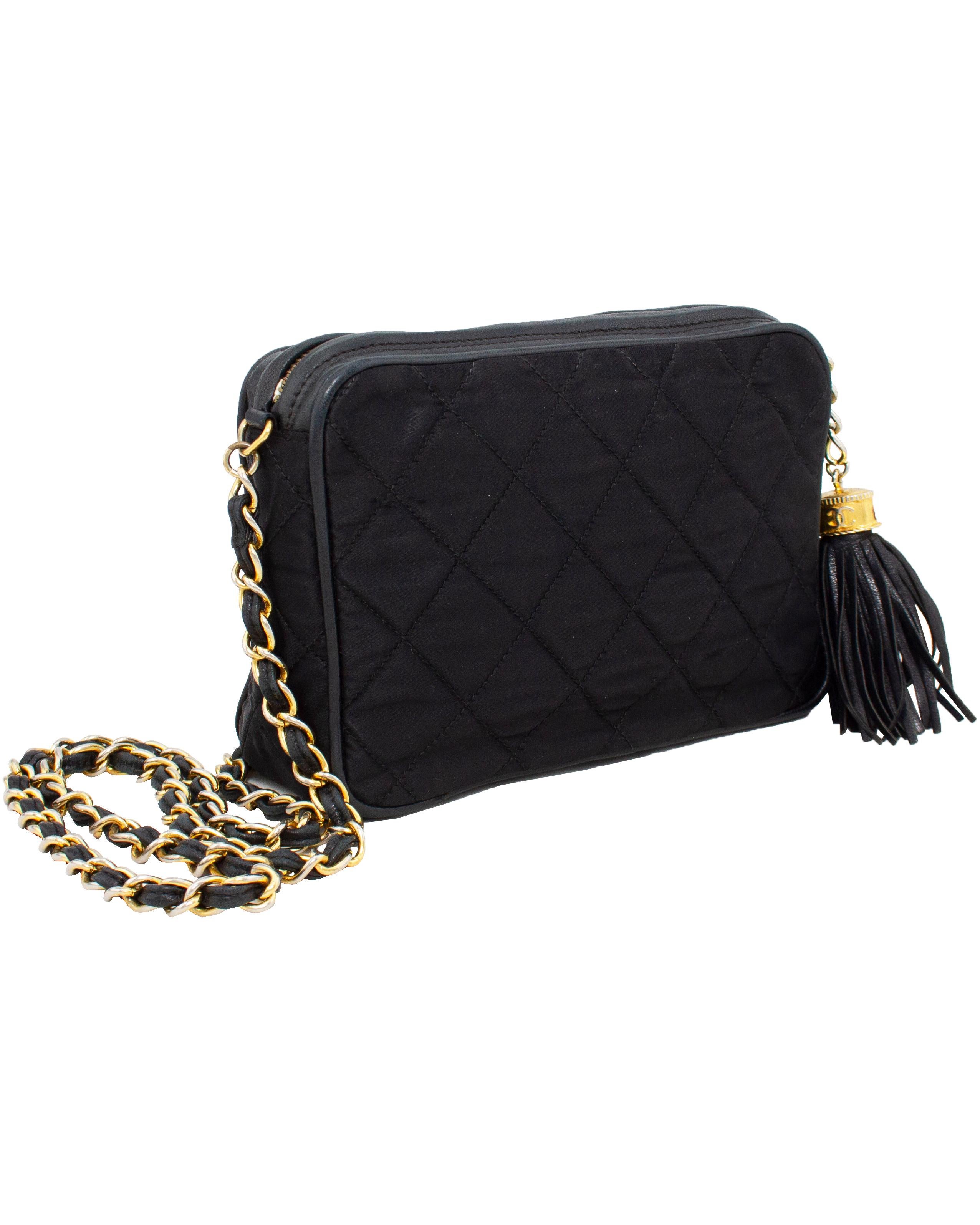 Classic 1980s Chanel black satin quilted evening bag with leather trim. The bag is in overall good vintage condition. There is visible wear on the leather trim and some of the goldplate has been rubbed off throughout. There are no tears or rips and