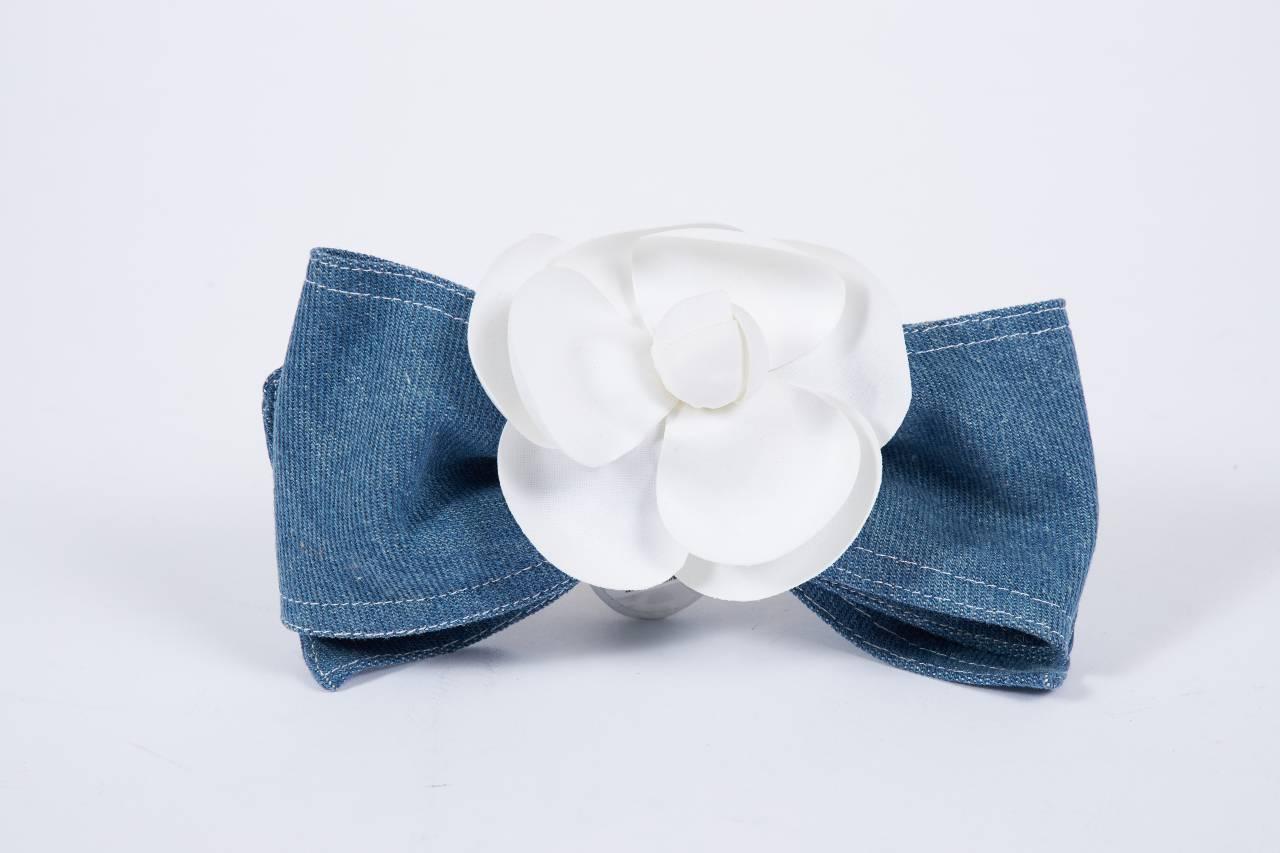 1980s Chanel denim bow hair clip topped with a white camellia flower. Mint condition. Comes with original box.