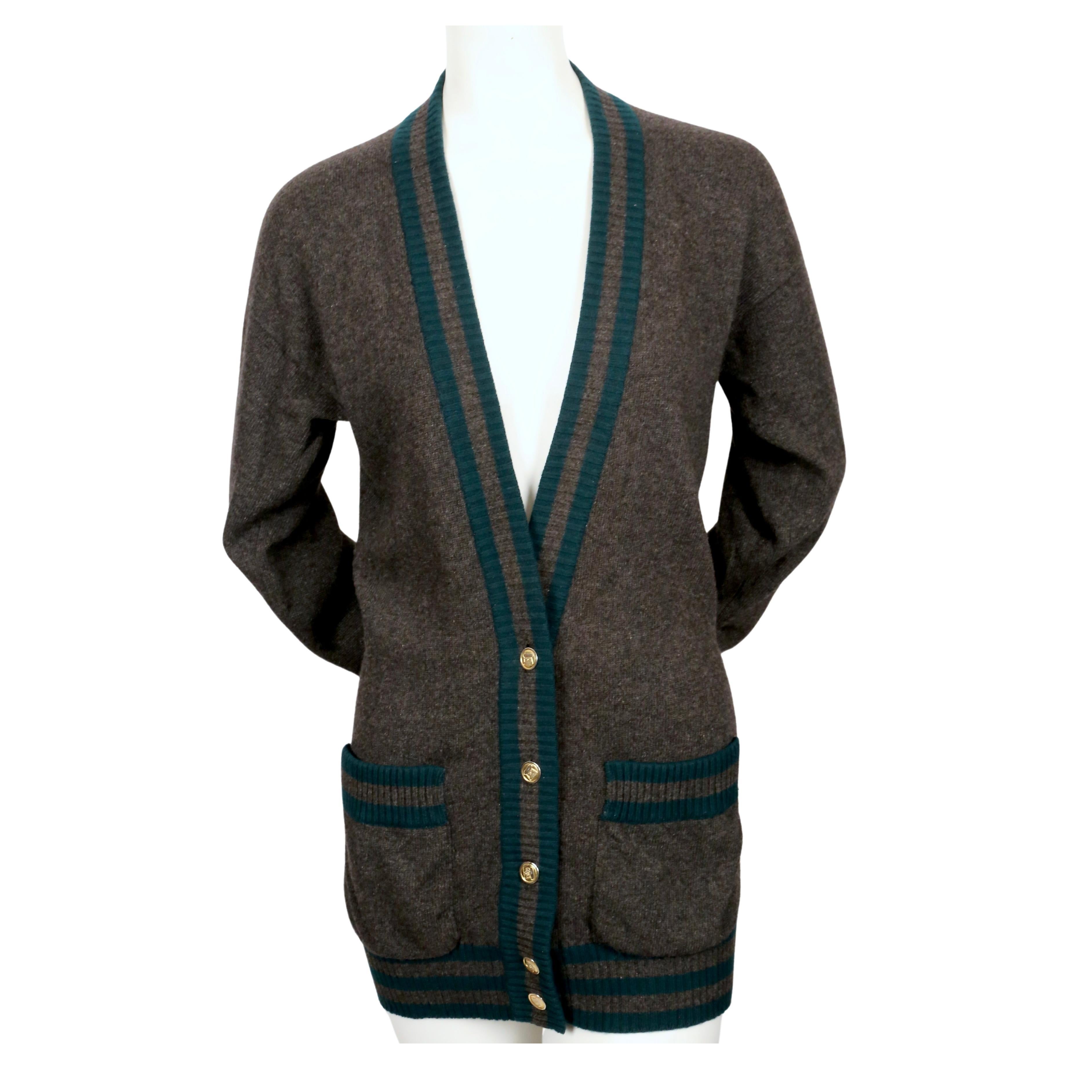 Classic charcoal grey and spruce cashmere cardigan with ribbed striped trip and gilt buttons from Chanel dating to the 1980's. Labeled a size M. Approximate measurements: drop shoulder 20