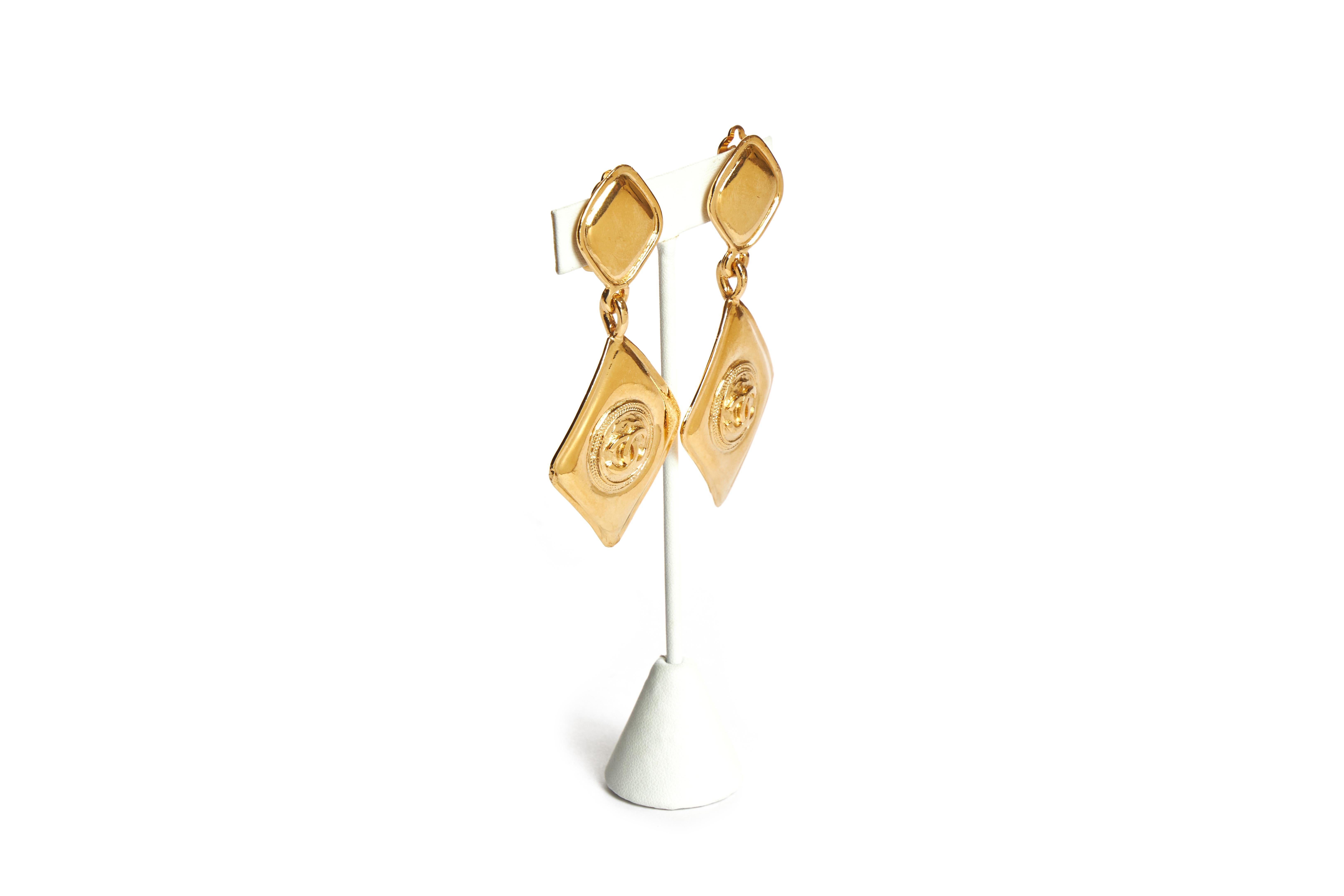 Chanel gold tone metal diamond-shaped logo drop earrings. Clip backs. 1980s collection. Comes with the original dust cover or box.