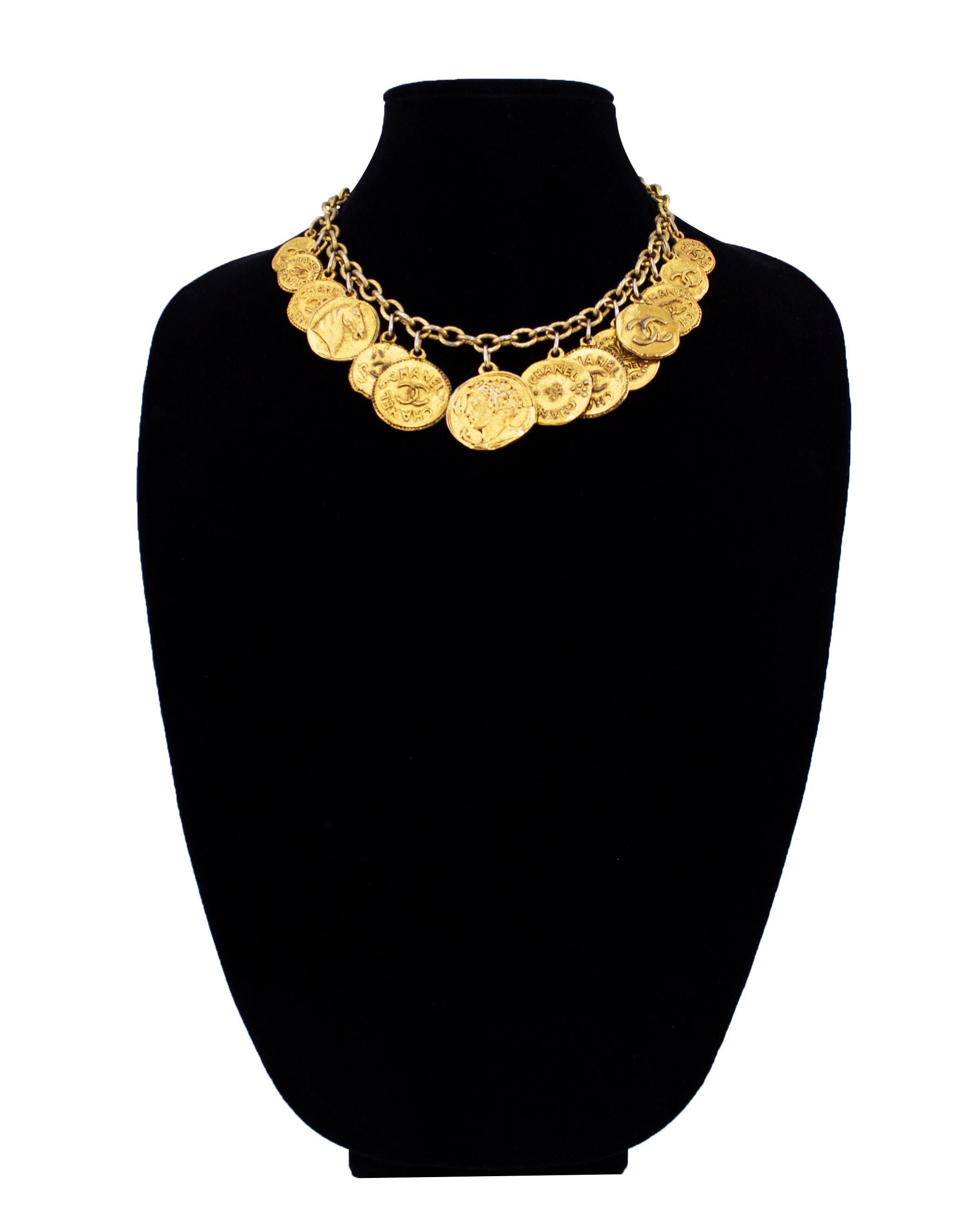 Fabulous 1980s gold tone metal Chanel necklace. Chain links with 14 hanging  Chanel coins. The coins are all different sizes with varying designs, mainly featuring the interlocking double C logo. All the coins were designed to have a