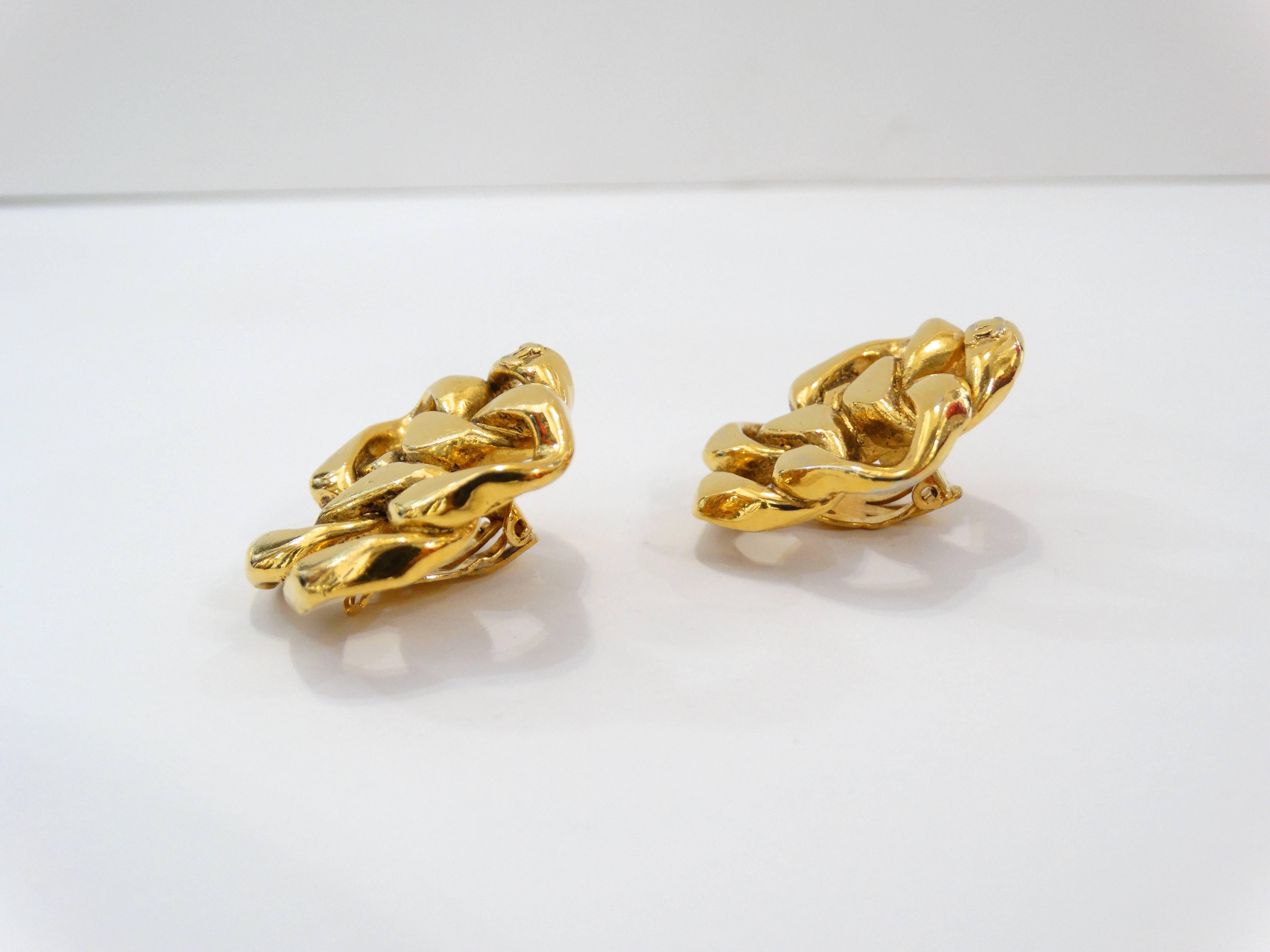Make a statement in our 1980s Chanel Chain earrings! Thick gold chain link arranged in a flower like silhouette. Small CC signature at the bottom of each earring. Clip on backs. Signature beneath clip fixtures. Signed Made in France Chanel 2 3