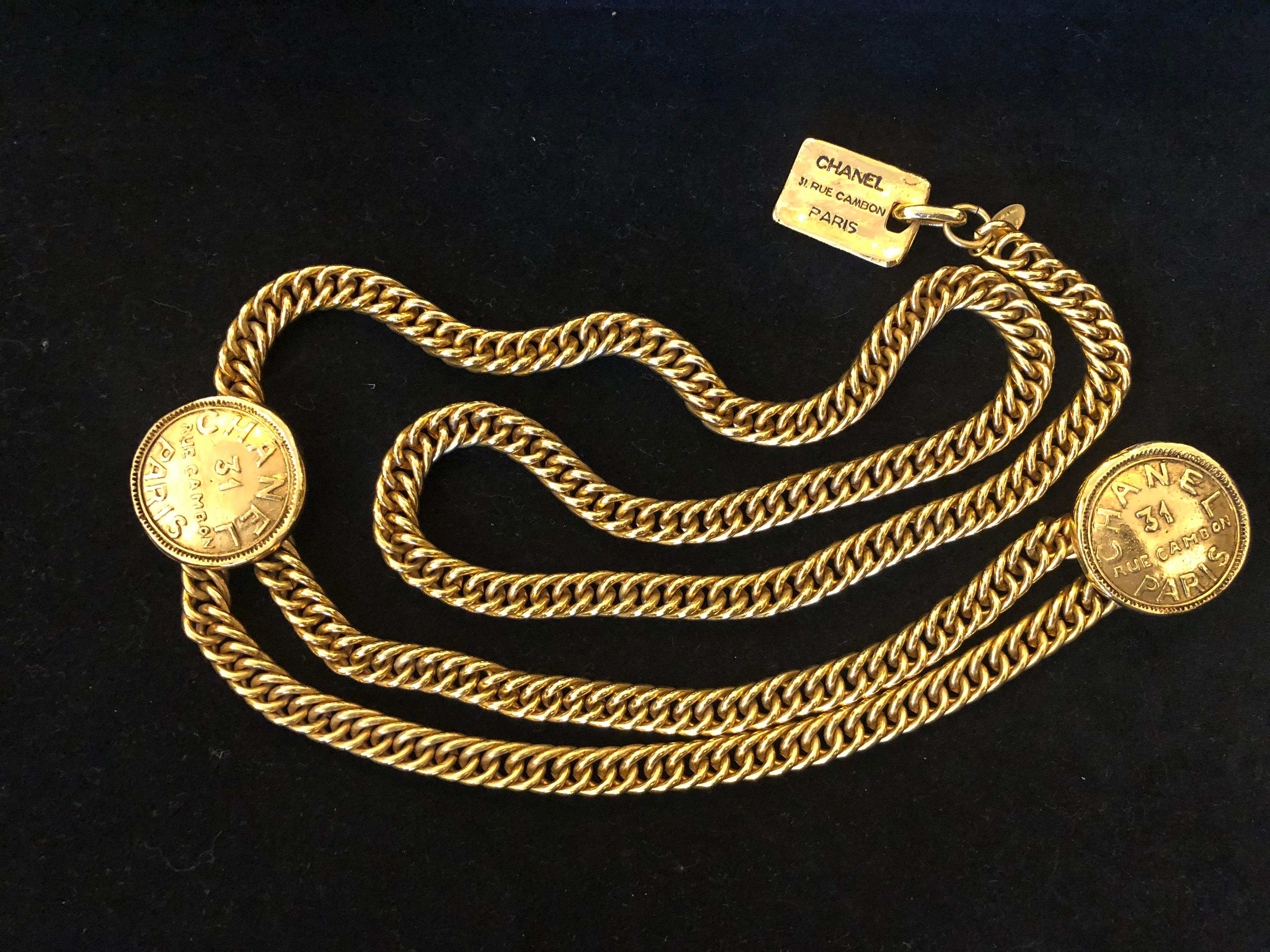 1980s Chanel gold toned chain belt featuring a double stranded front joined by two Cambon medallions and a dangly Cambon charm. Adjustable hook fastening. It can be worn as a necklace or belt. Stamped Chanel made in France. Length approximately 84