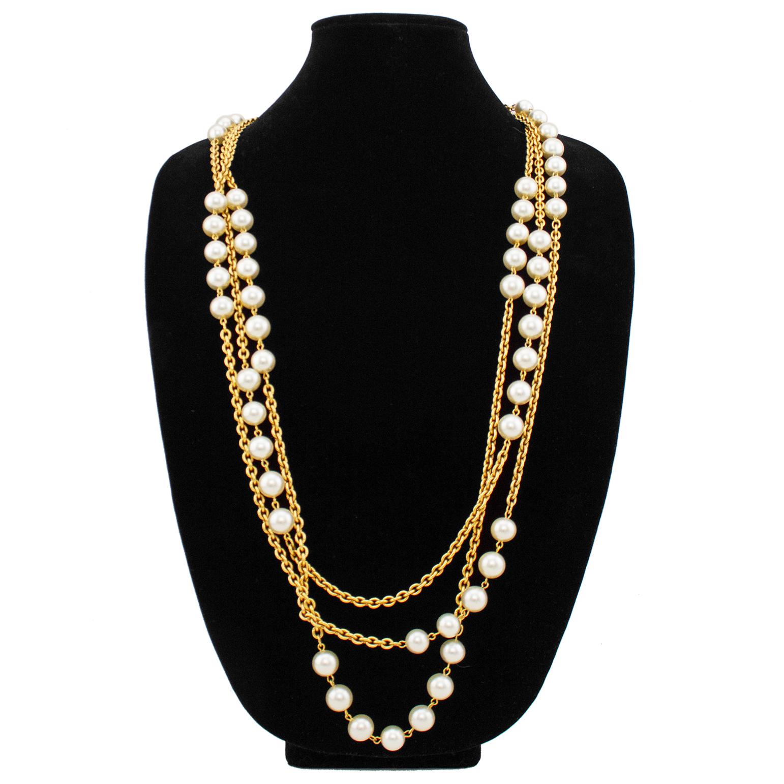 Fabulous large Chanel necklace from the late 1980s. Triple strand gold tone chain links with large faux pearls throughout. Two large gold tone jump rings at ends with a spring ring clasp. Hanging matching gold tone oval tag with brand stampings.