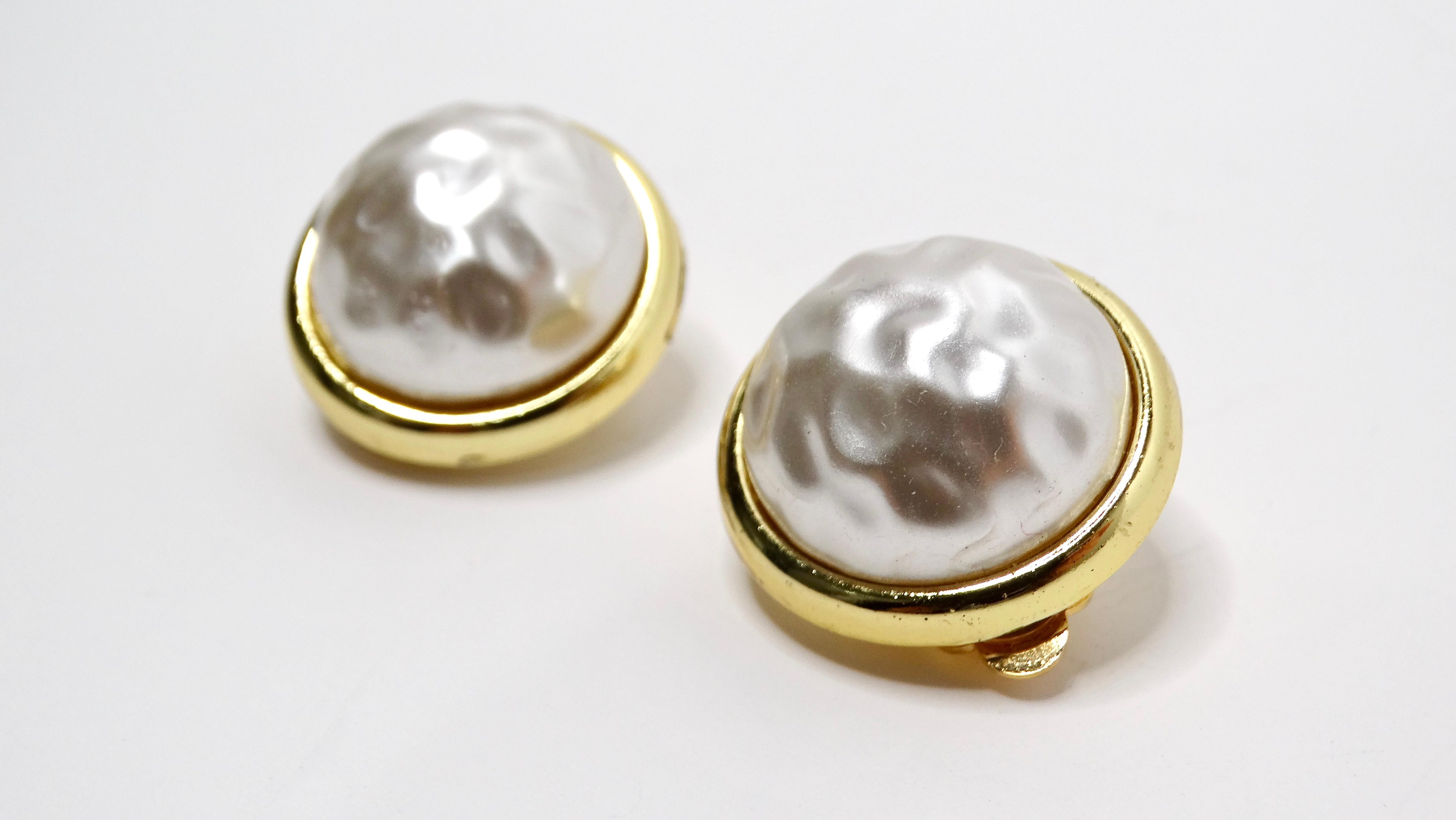 Elevate your jewelry collection with these stunning 1980s Chanel Inspired 14k Gold Plated Costume Pearl Clip-On Earrings. Featuring a striking circular costume pearl center, these earrings are elegantly framed by lustrous 14k gold plating. The