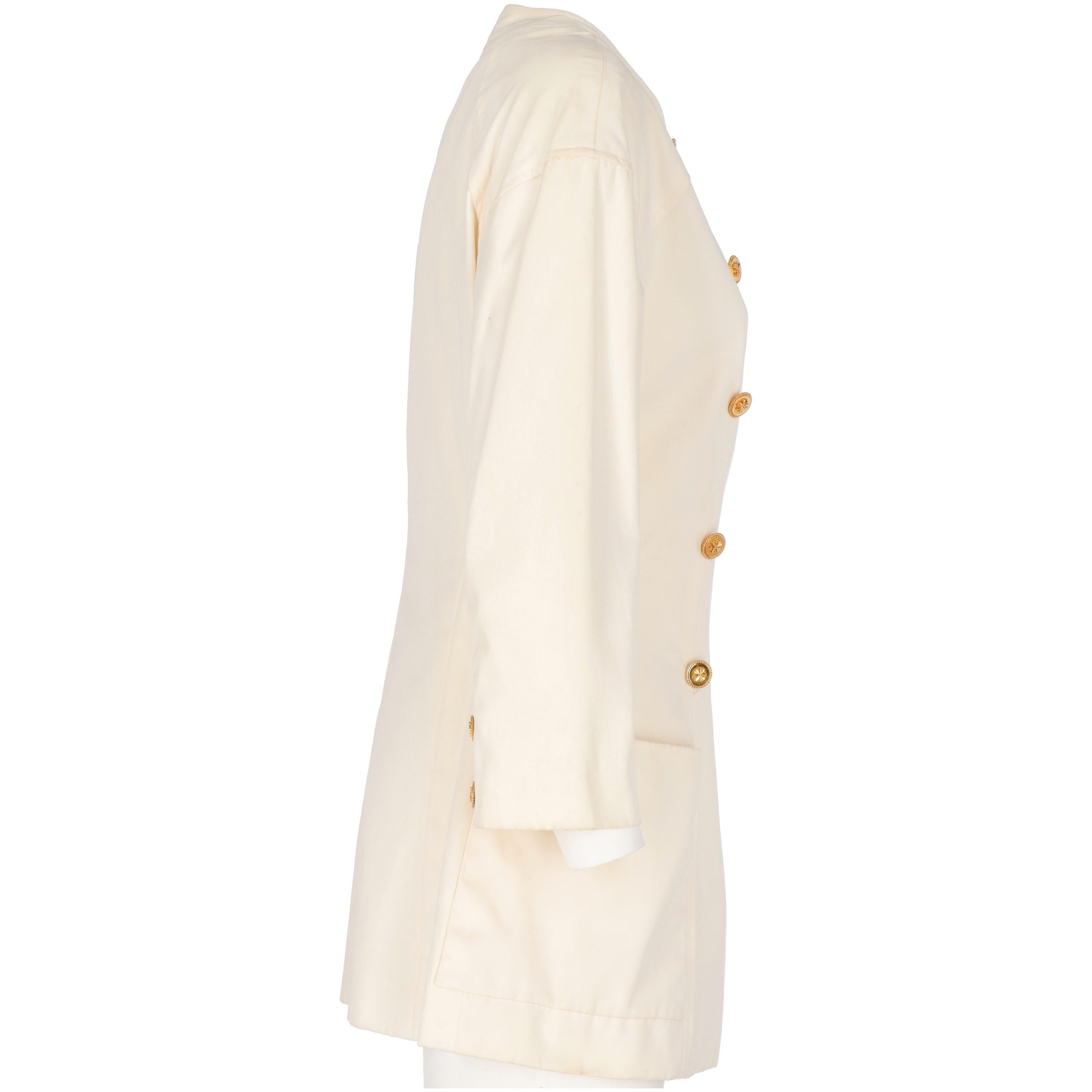 Marvellous Chanel double-breasted jacket in white ivory cotton with a slightly flared cut.
It features a crew neck with two metal tiny press-studs under the collar and two decorative buttons in shiny gold-tone metal with thick details. Midi lenght
