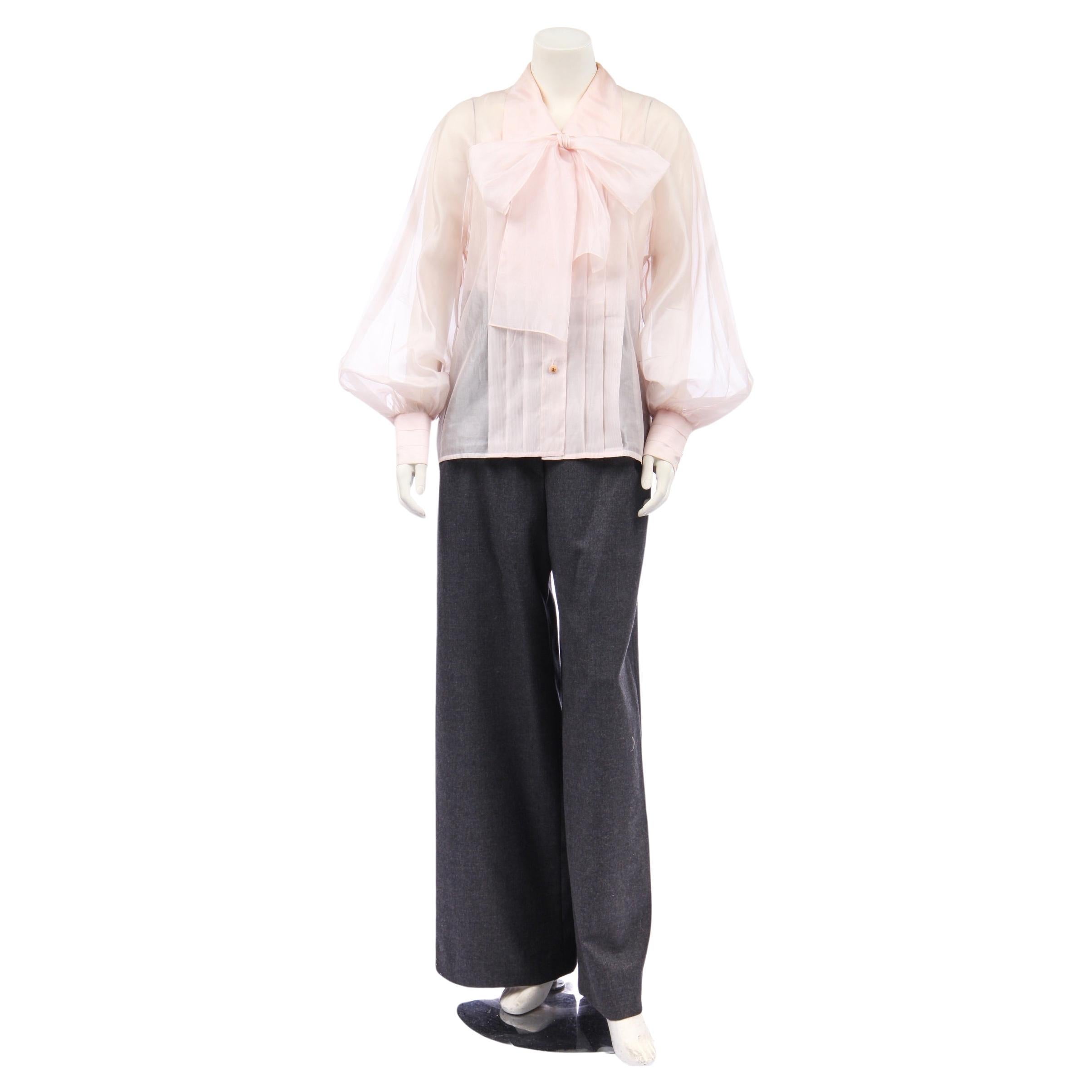 - Chanel
- Karl Lagerfeld Era
- 1980s
- Blouse & Camisole
- Detachable Bow
- Blush Pink
- Silk Organza
- Pleated Detail on Front and Back
- Balloon Sleeves
- Pleated Button Cuffs
- Pink Buttons with Gold Shamrock Detail
- Made in France
- Sold by