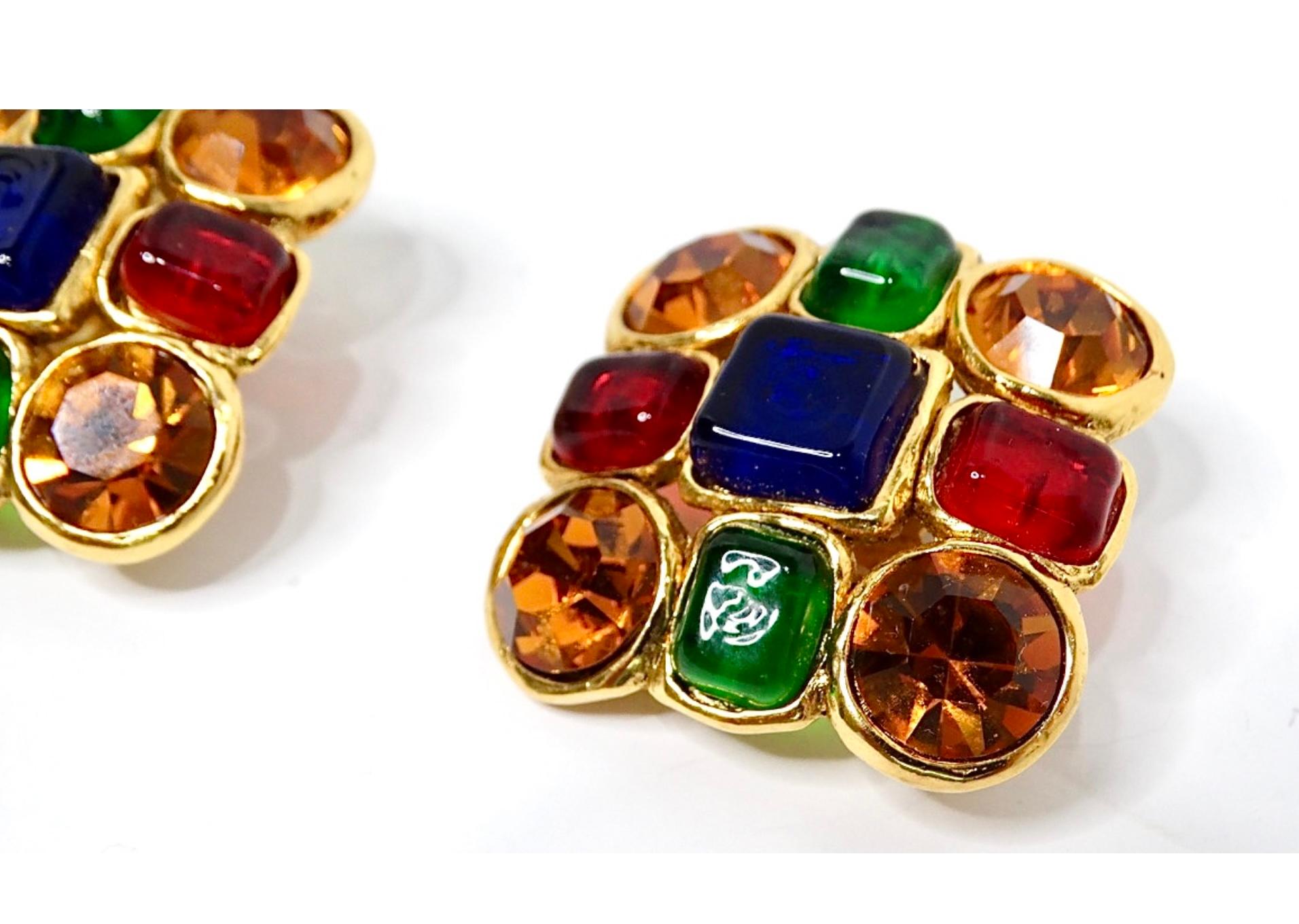 Los icónicos Pendientes Chanel Grandes Multicolores Gripoix Dorados de los años 80 son una impresionante representación de la elegancia única y el vibrante arte de la marca. Con una deslumbrante gama de colores joya -azules intensos, verdes