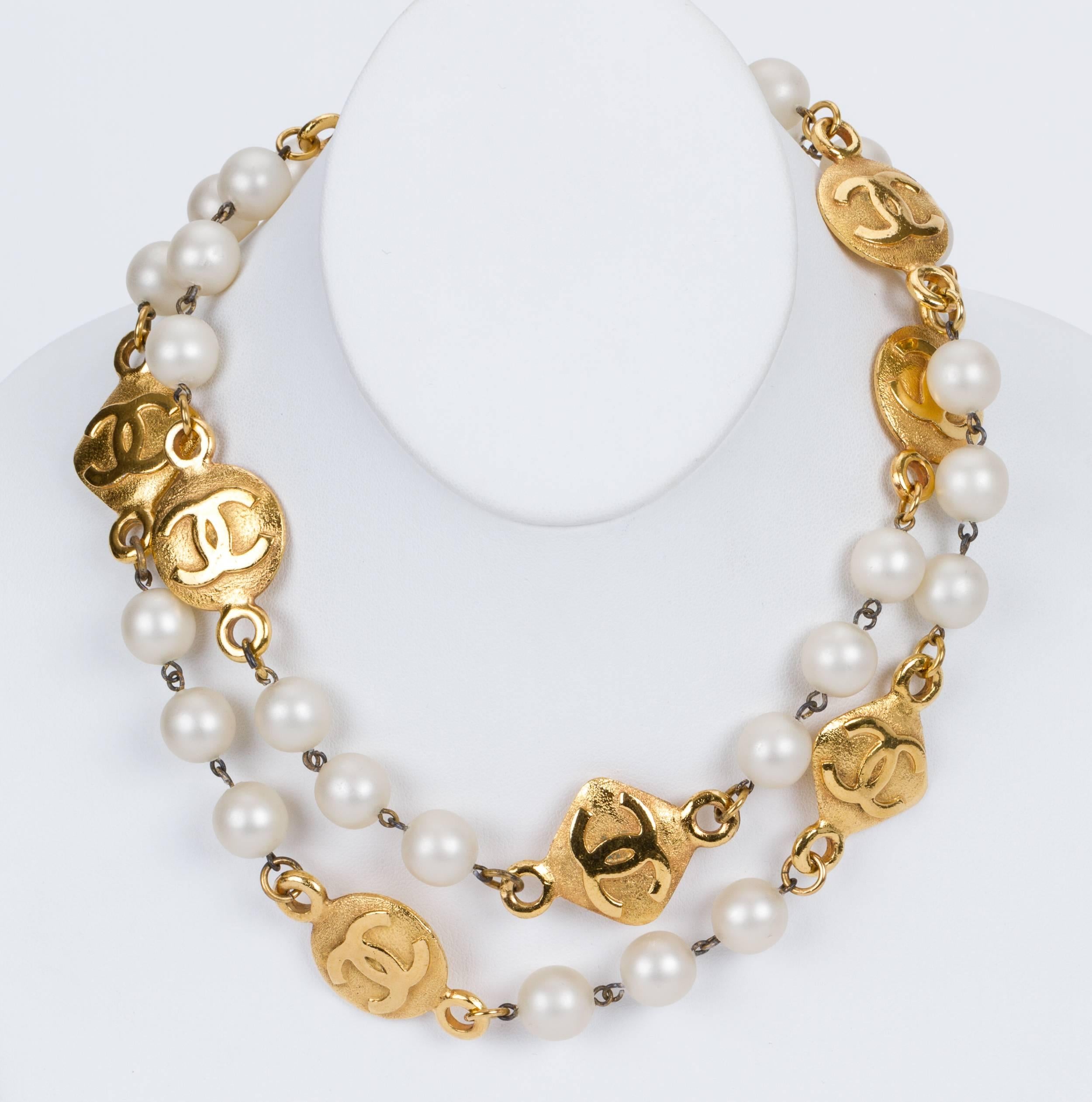 Chanel large pearl necklace with satin cc logo coins. Minor scuffs on pearls. Collection 2 cc 9, late 80s. Comes with original box.