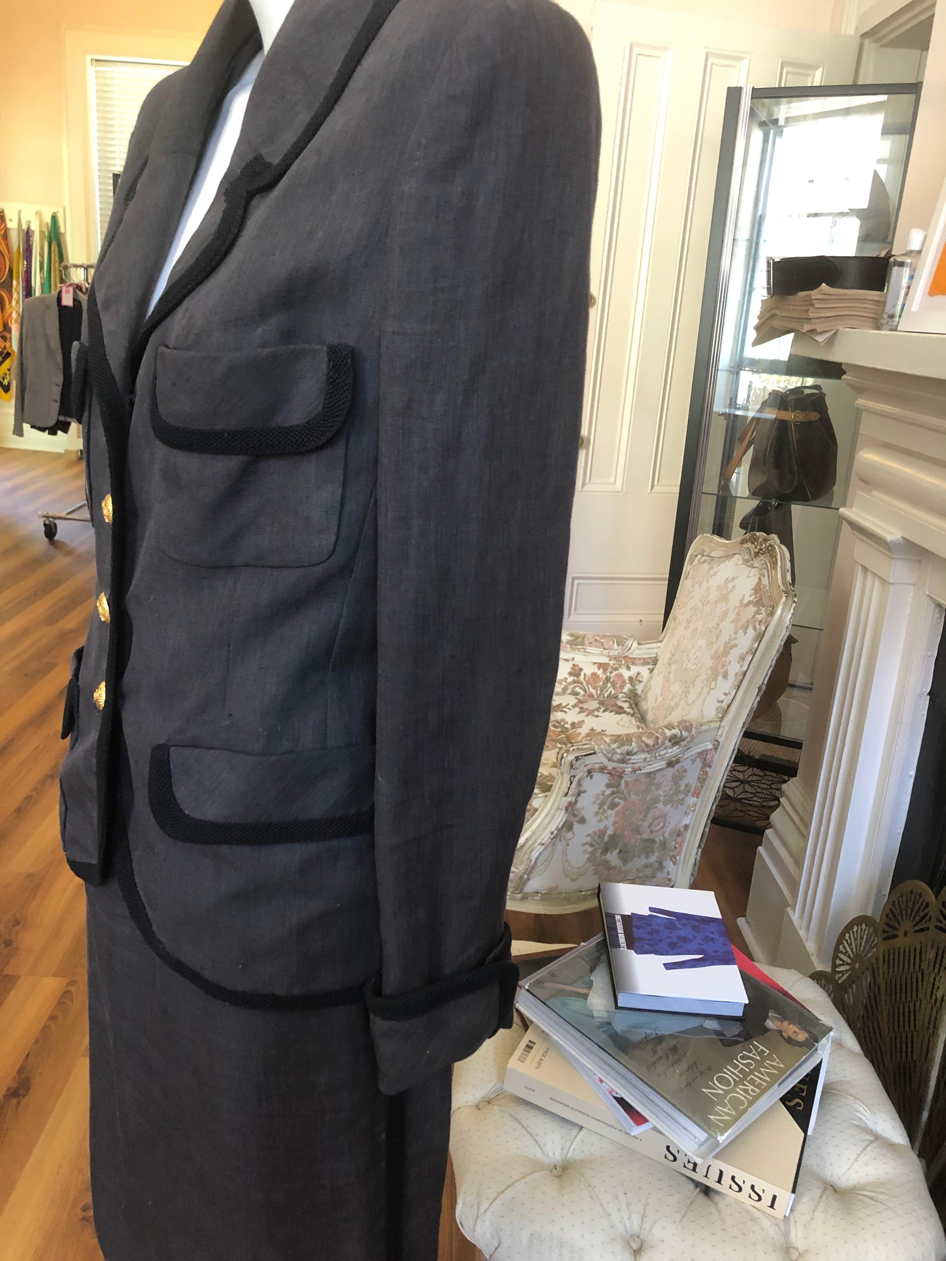 This is a late 1980s linen suit, with black braiding accents, on both the jacket and the skirt. The suit was designed by Karl Lagerfeld and is part of Collection 22. It has a notched lapel; cc silk lining; four pockets, and beautiful gold tone