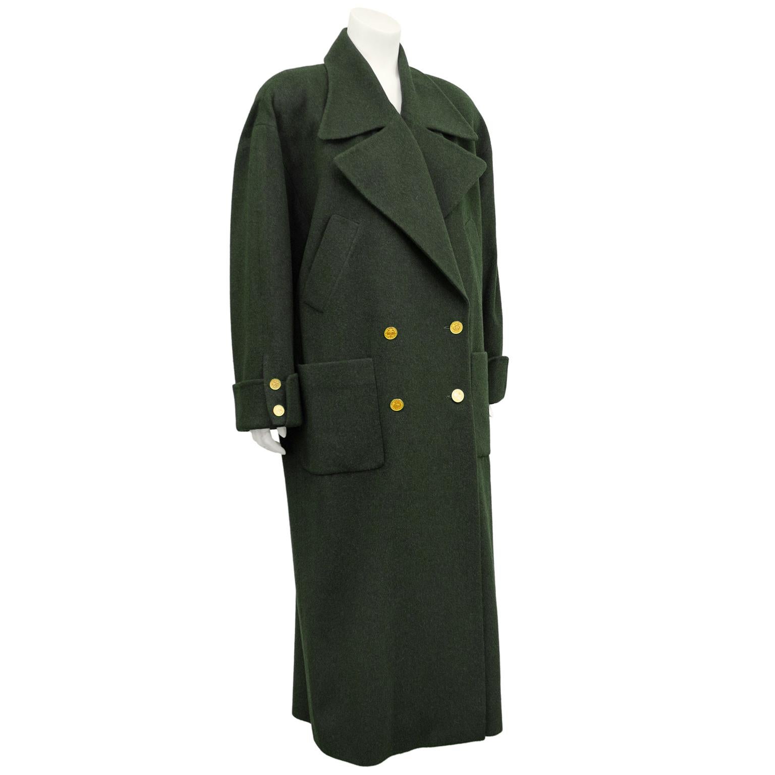 1980s Chanel olive green double breasted trench coat. 100% wool with beautiful gold CC logo and crown buttons. Exaggerated notched collar, slanted slit pockets and large patch pockets at hips. Cuffed at wrists. Corresponding olive green lining.